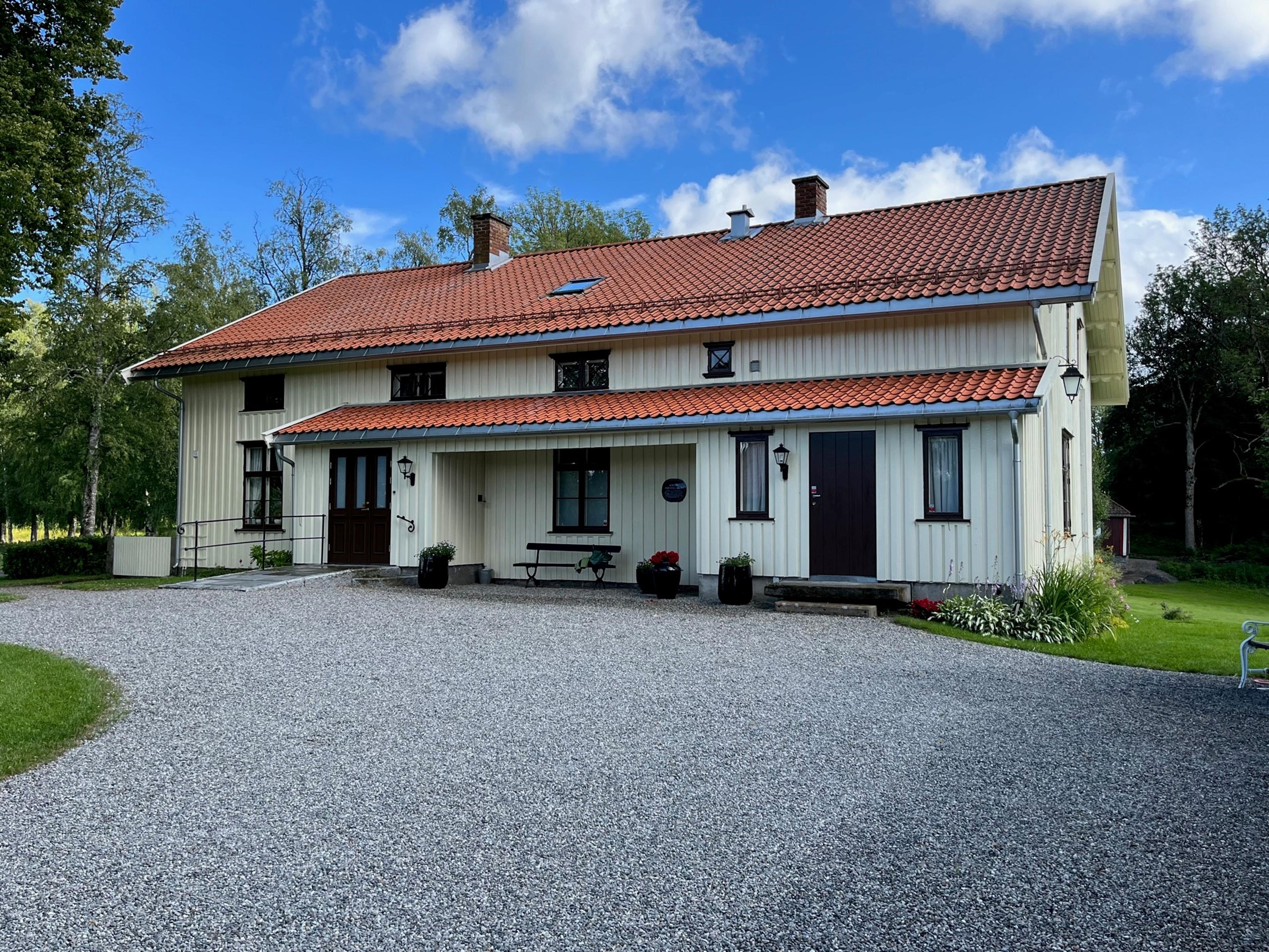 Et lyst hus med rødt tak