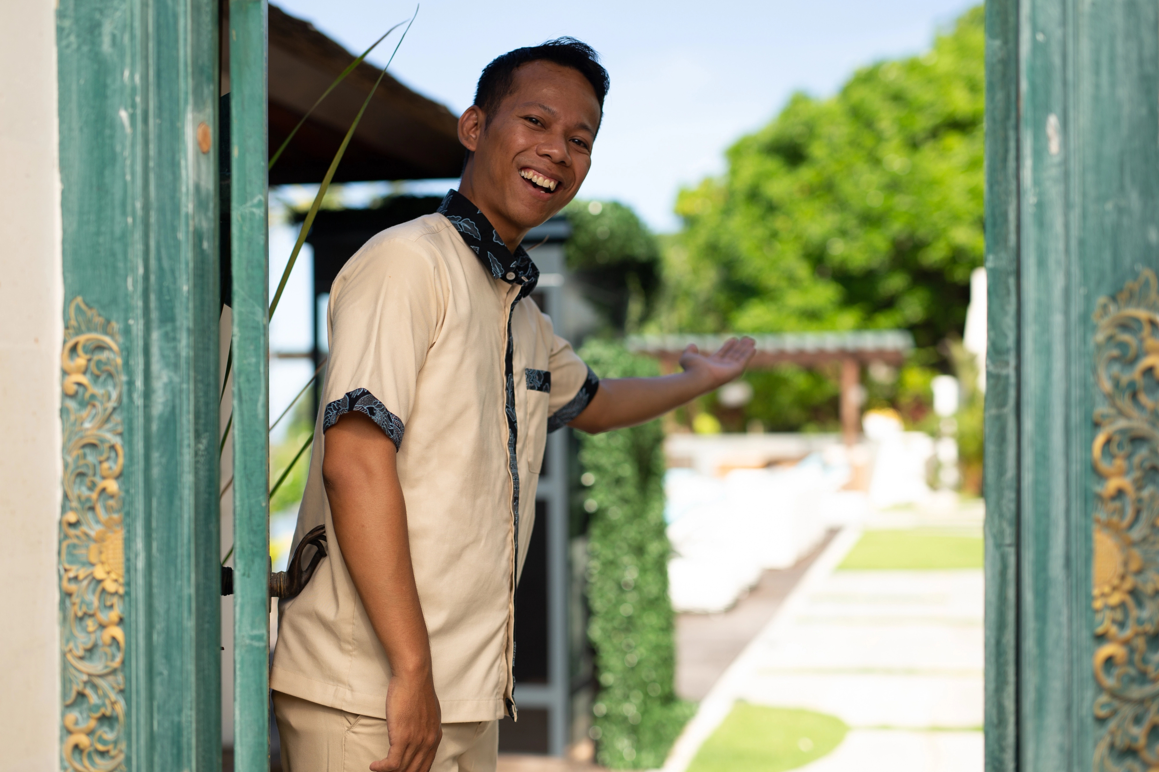 Picture of our staff member welcoming with a big smile while opening the door at Melloni Cliff Castle