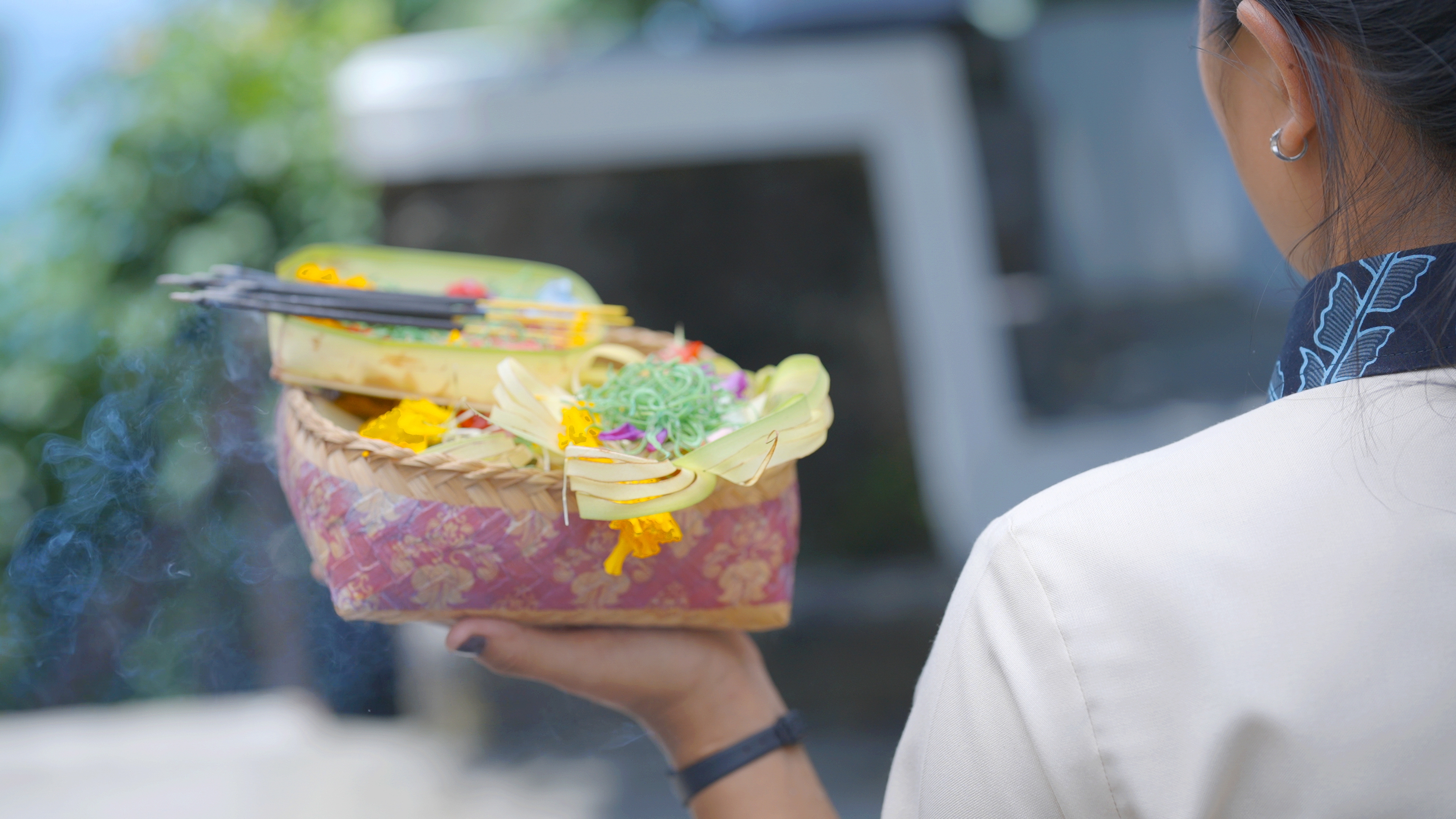 Image of our staff carrying canang sari offerings as part of the morning ritual at Melloni Cliff Castle.