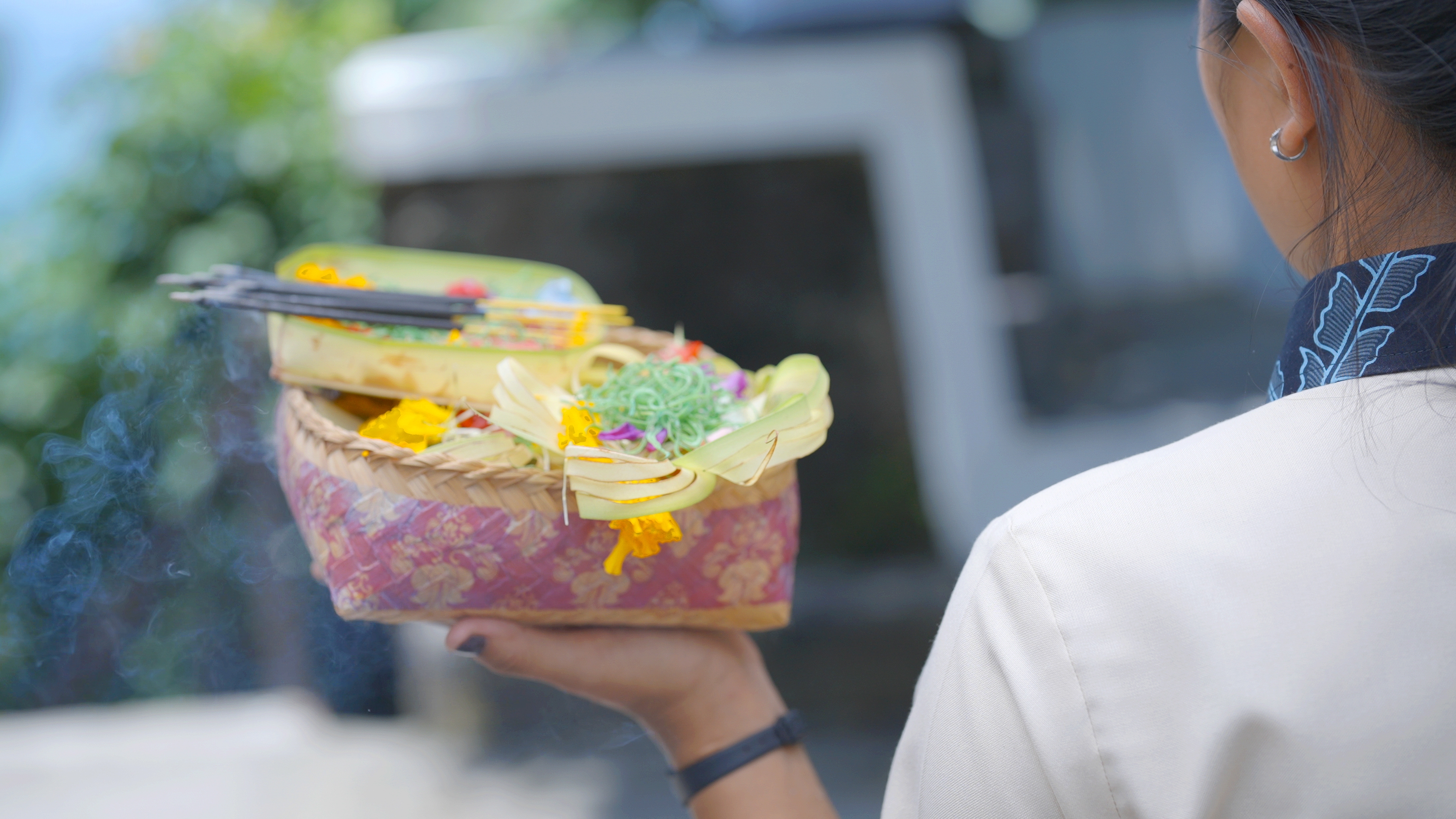 Image of our staff carrying canang sari offerings as part of the morning ritual at Melloni Cliff Castle.