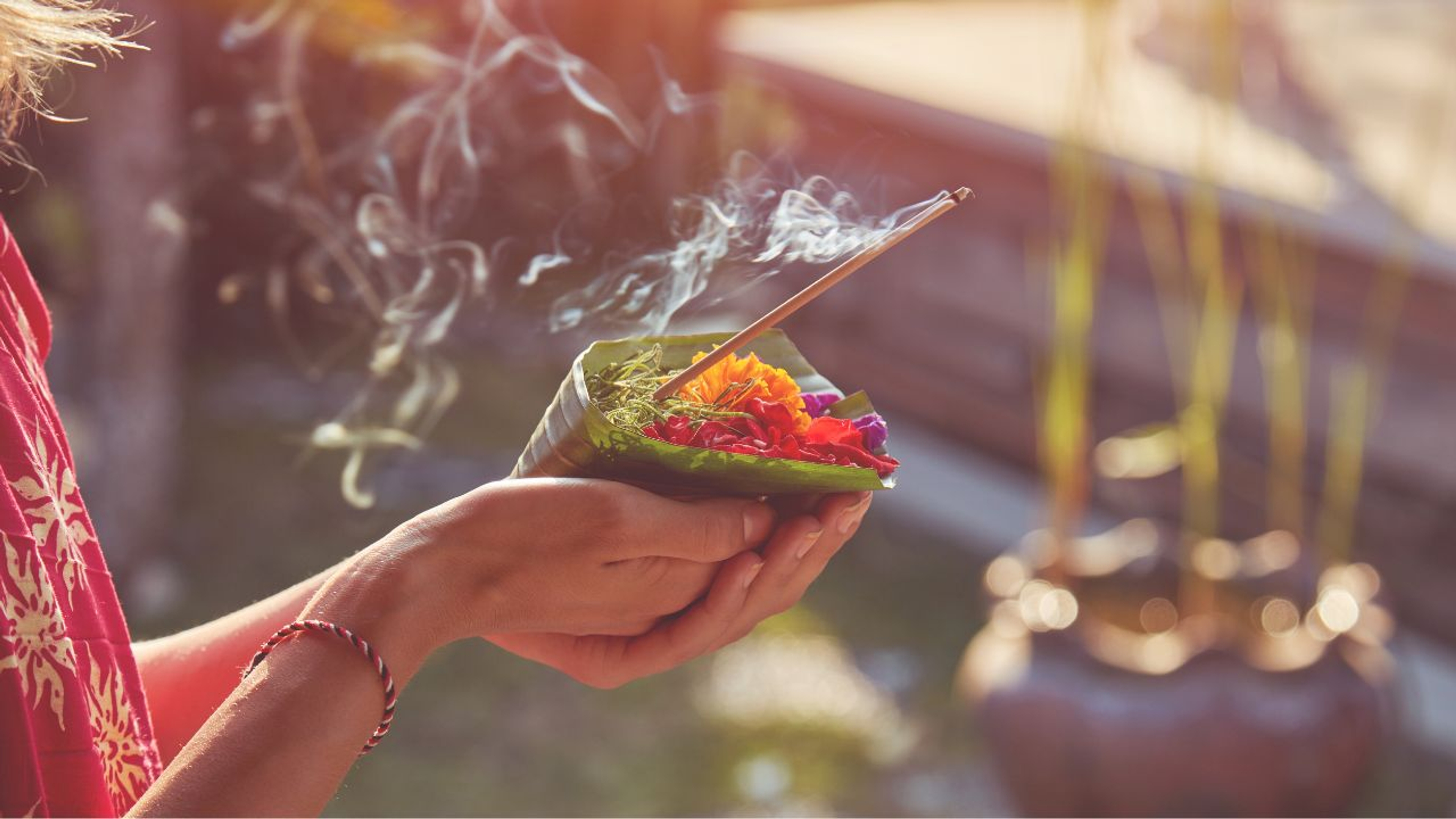 Picture of woman's hands holding offering during Melukat ceremony 