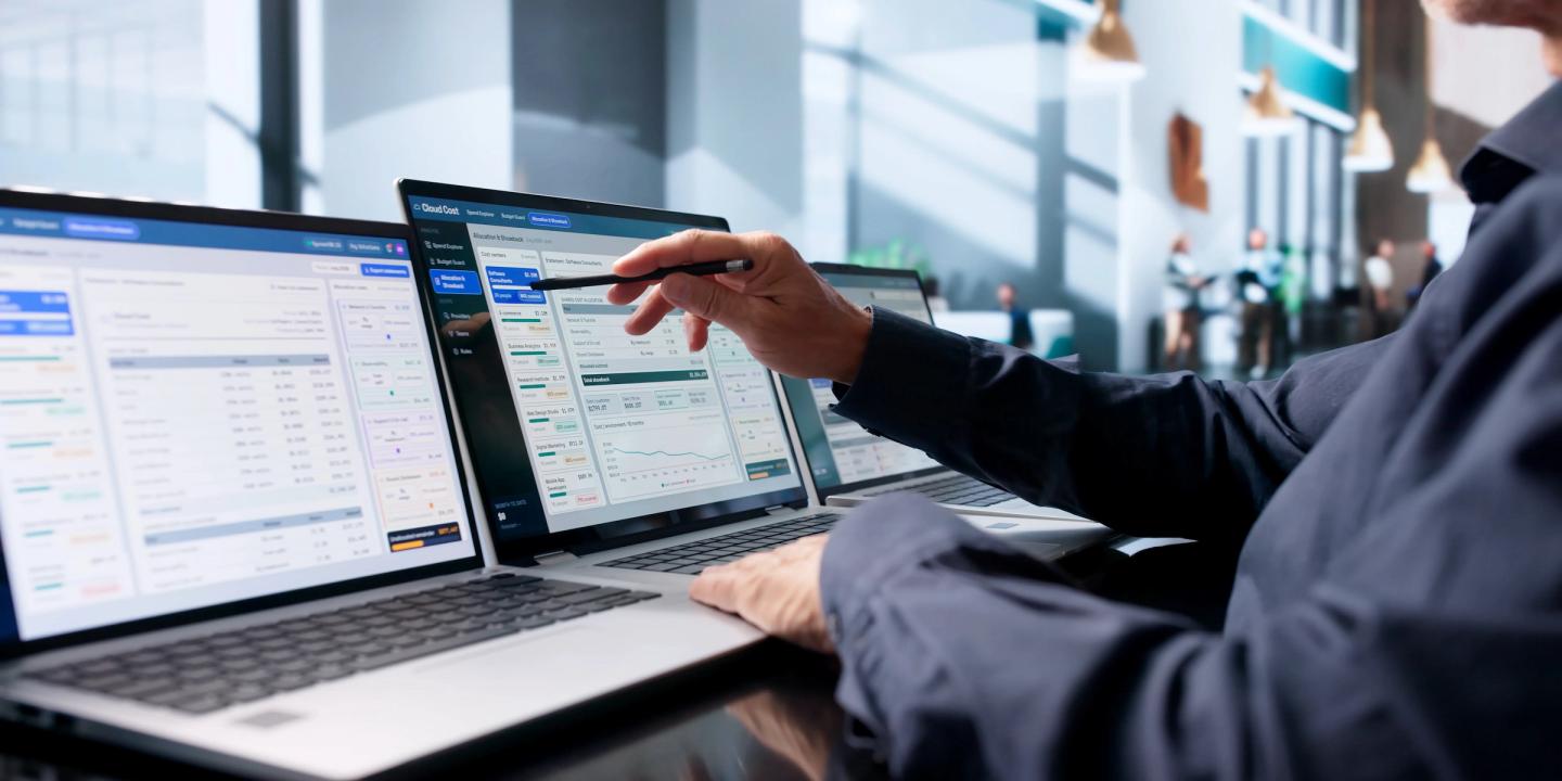 Person comparing software dashboards on multiple laptops while evaluating custom and off-the-shelf software options.