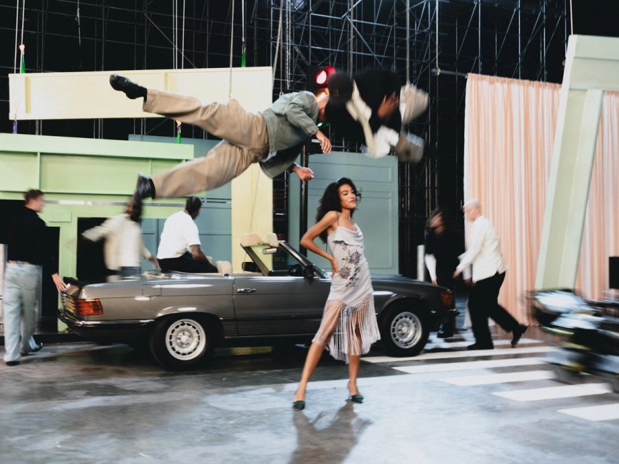 Olivia Dean dancing in front of a 1984 Mercedes SL500
