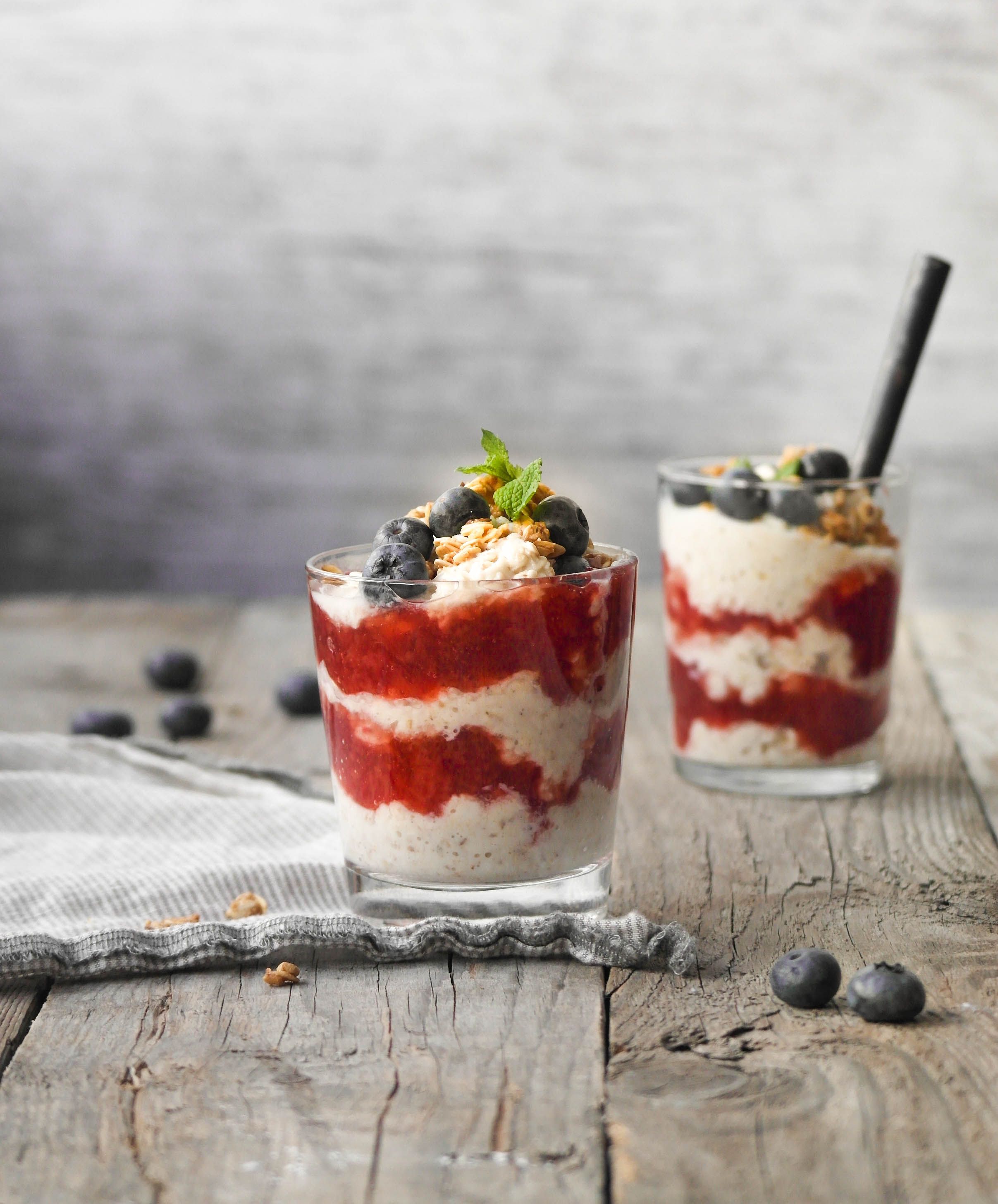 Havregrøt i et glass med jordbær syltetøy og ferske blåbær med granola