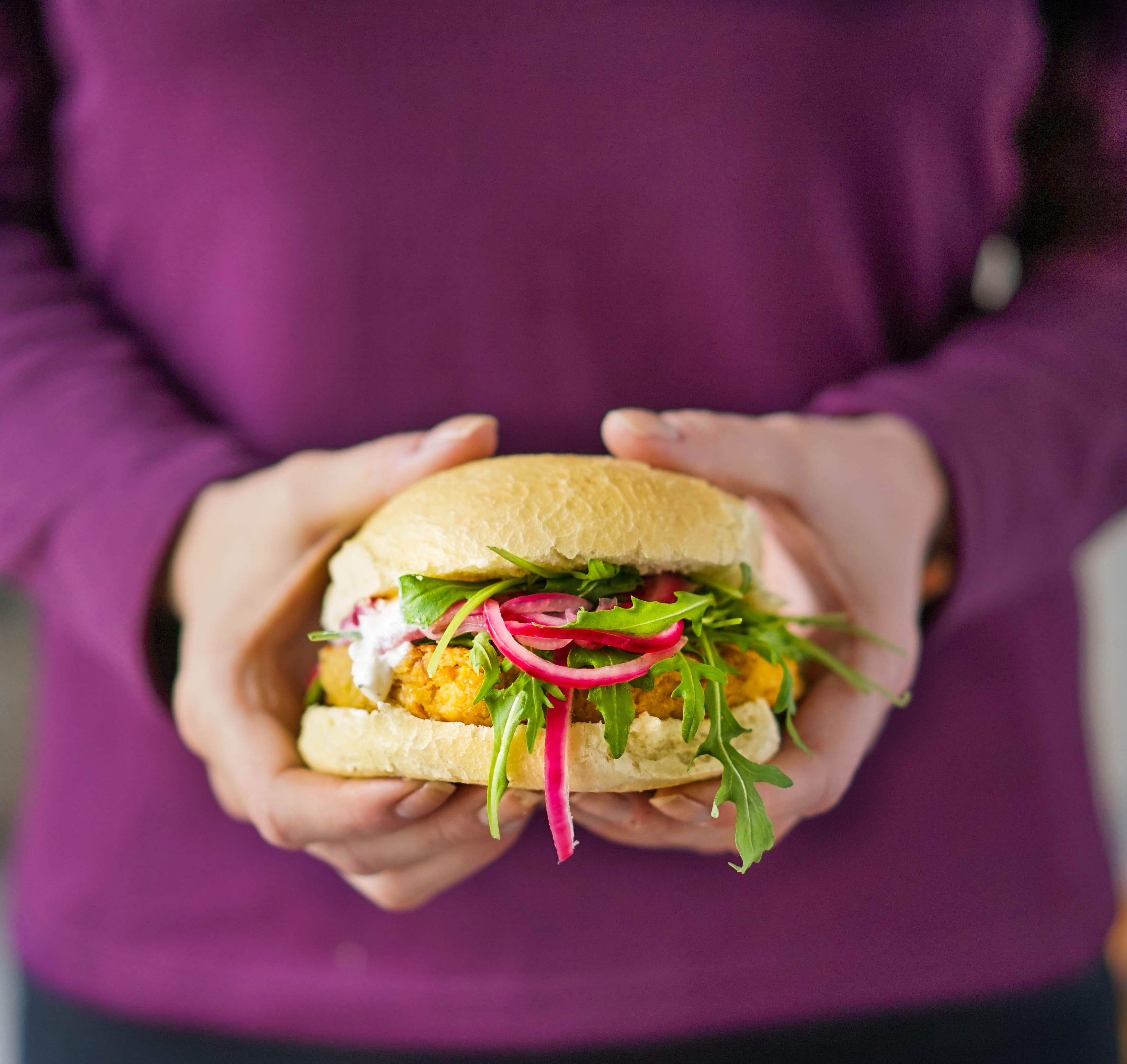 Vegetarburger holdes fram av en person