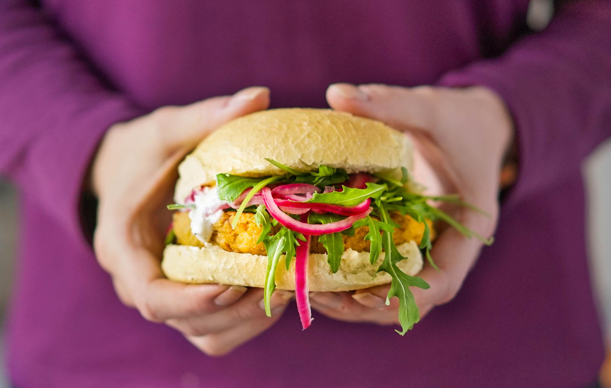 Vegetarburger holdes fram av en person