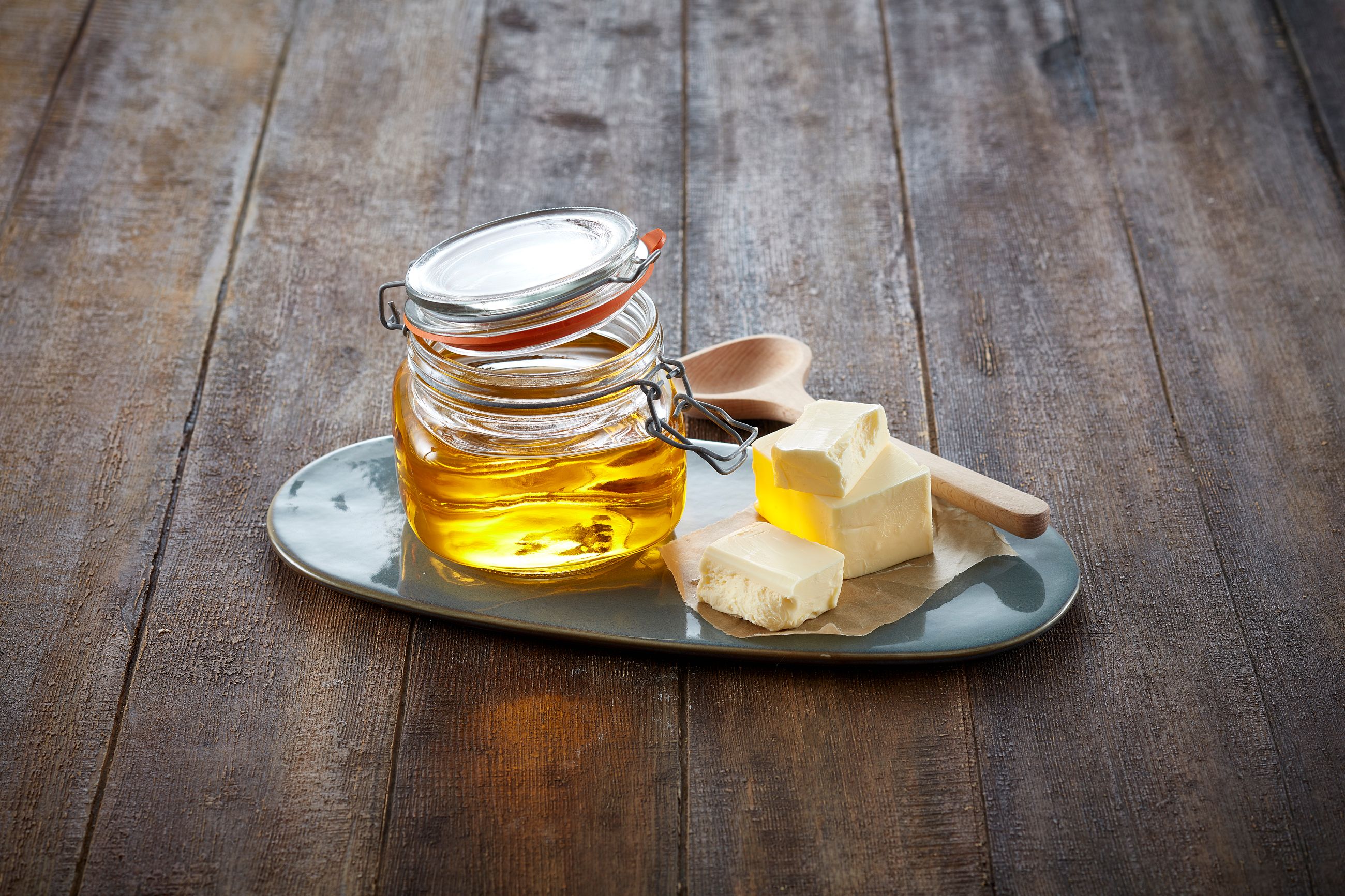 Klaret smør i en krukke, med skiver av smør ved siden av 
