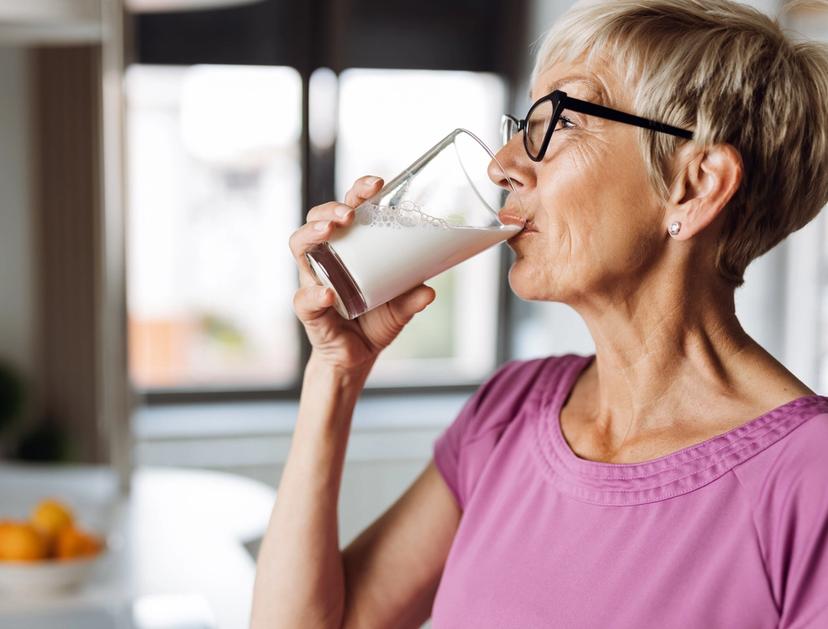 Voksen dame som drikker et glass melk