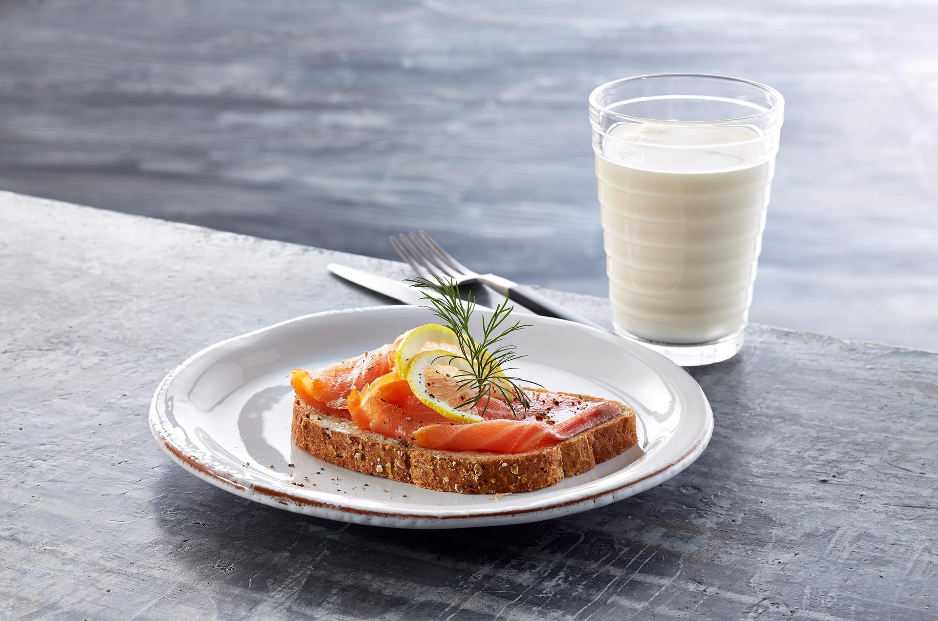 Brødskiver med laks og et glass melk