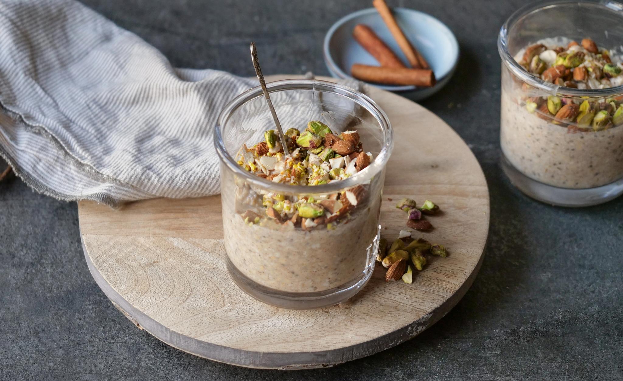 Et glass med grøt toppet med hakkede nøtter.