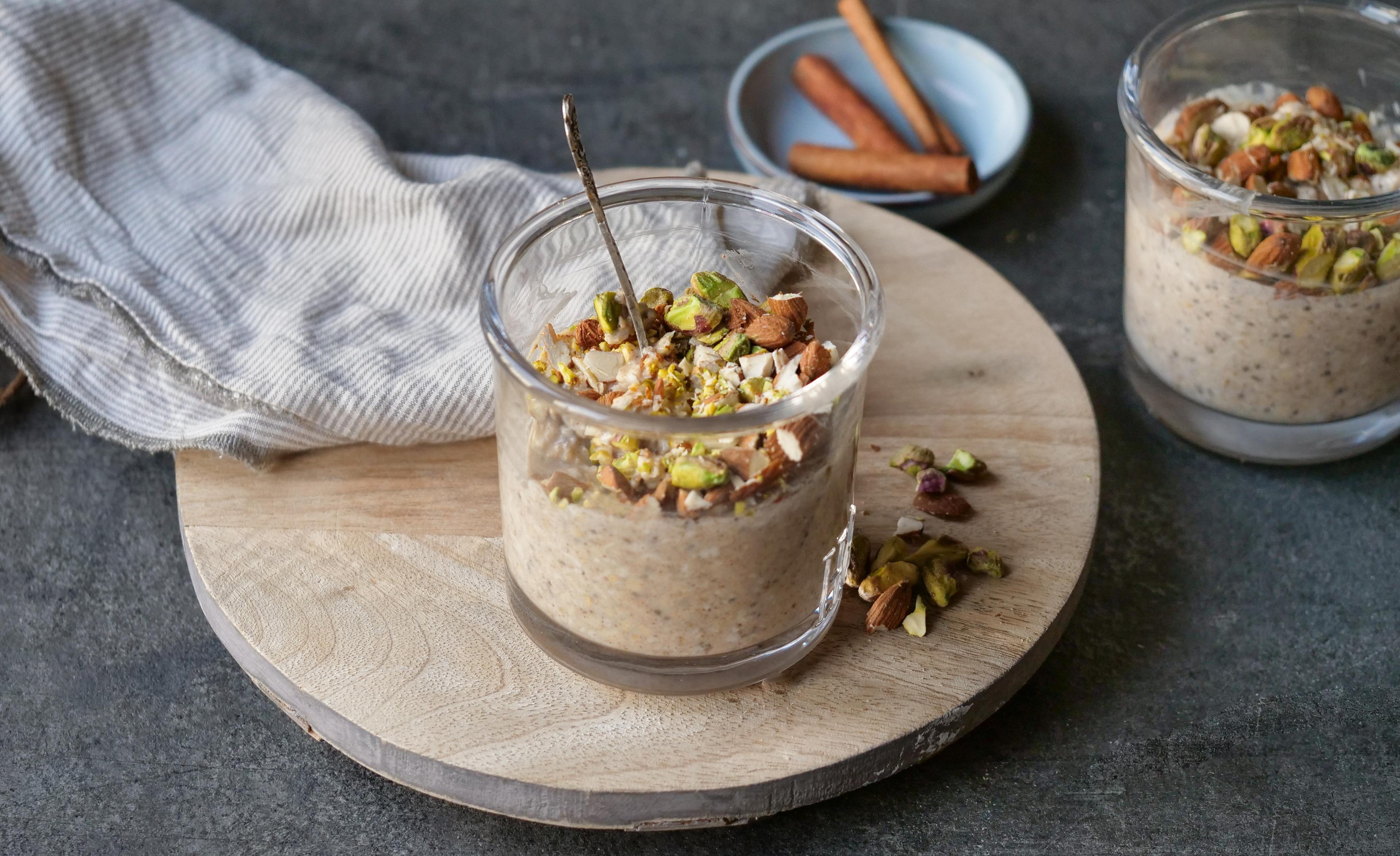 Et glass med grøt toppet med hakkede nøtter.