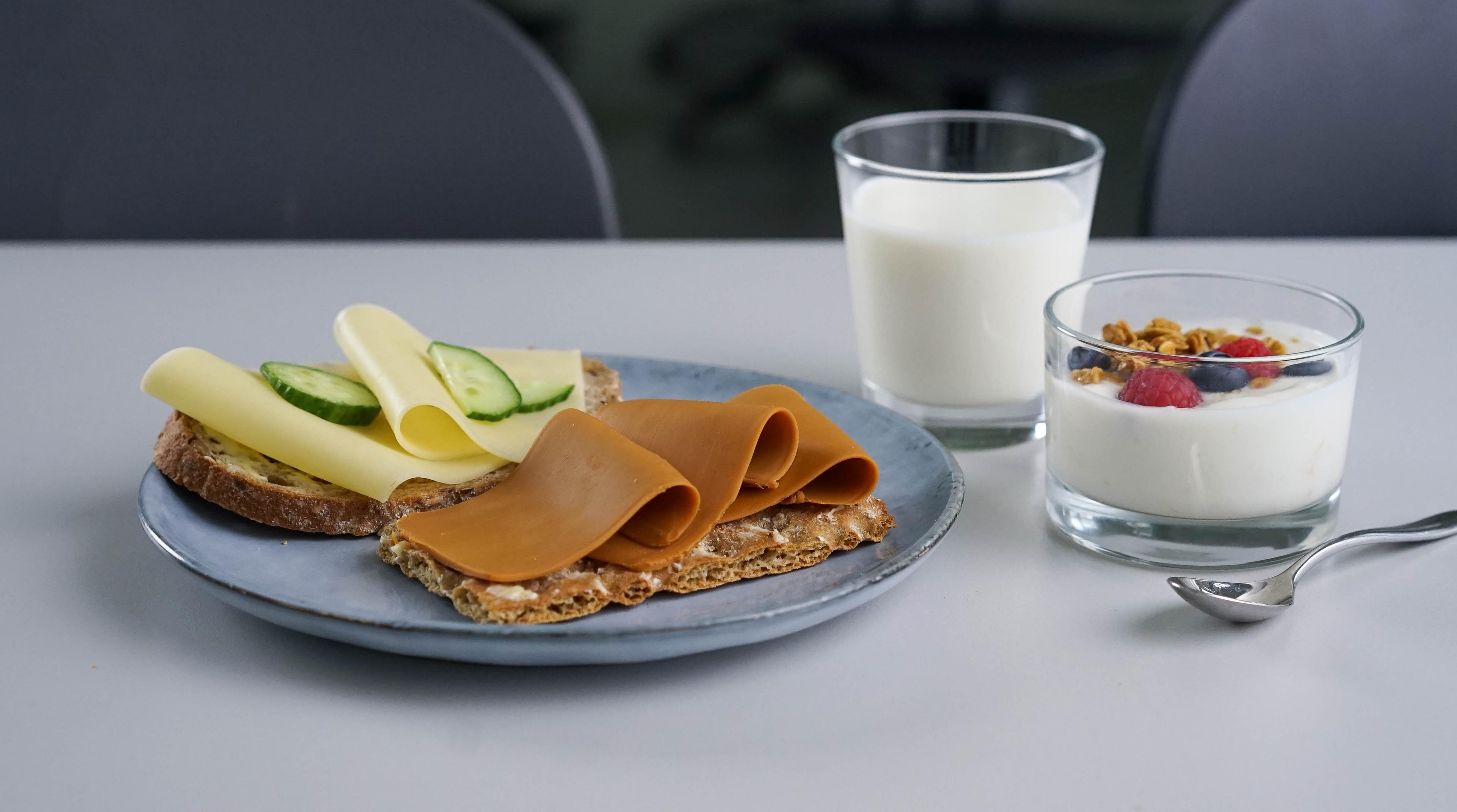 a plate of food and a glass of milk on a table .