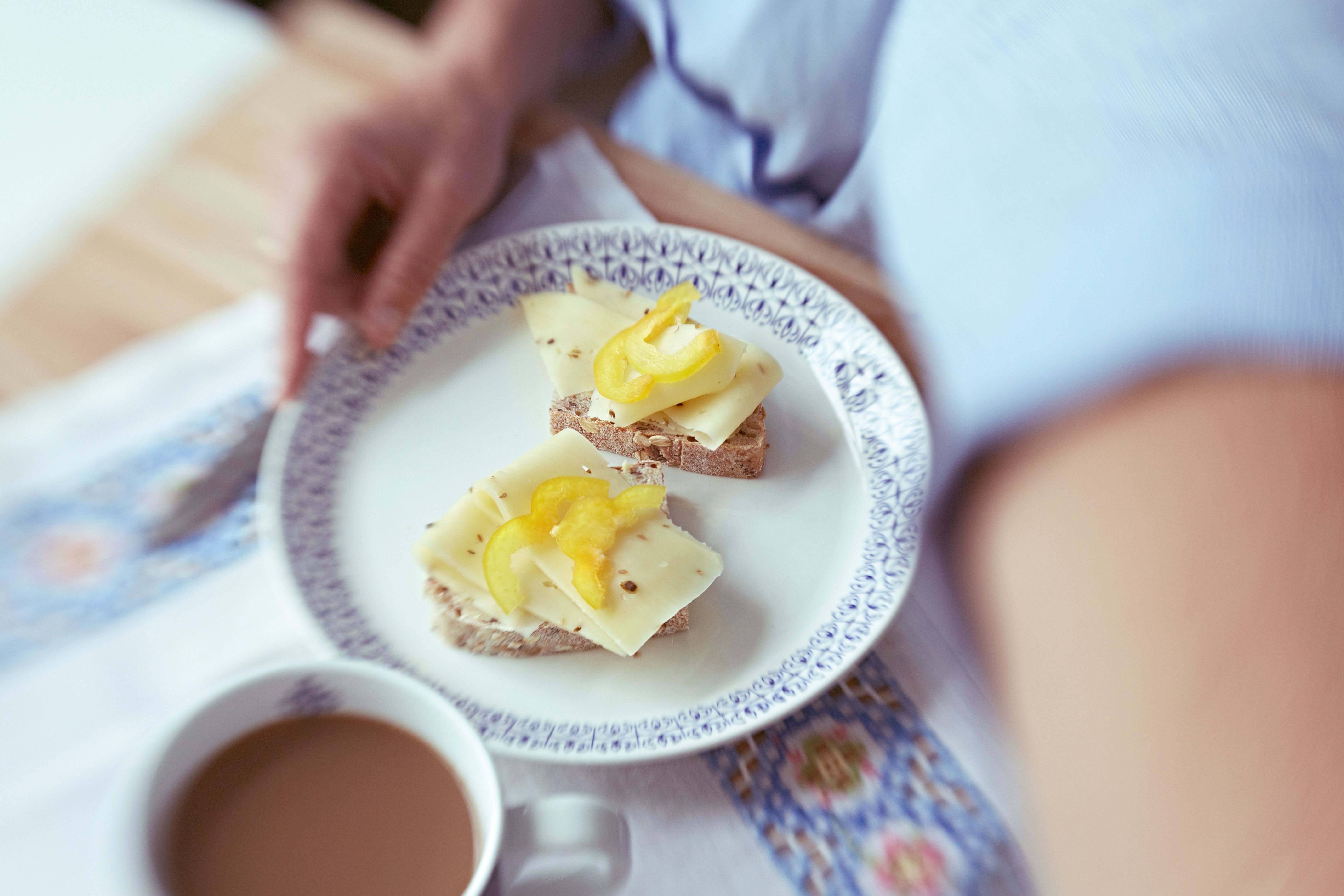 To brødskived med gulost og gul paprika på en tallerken.