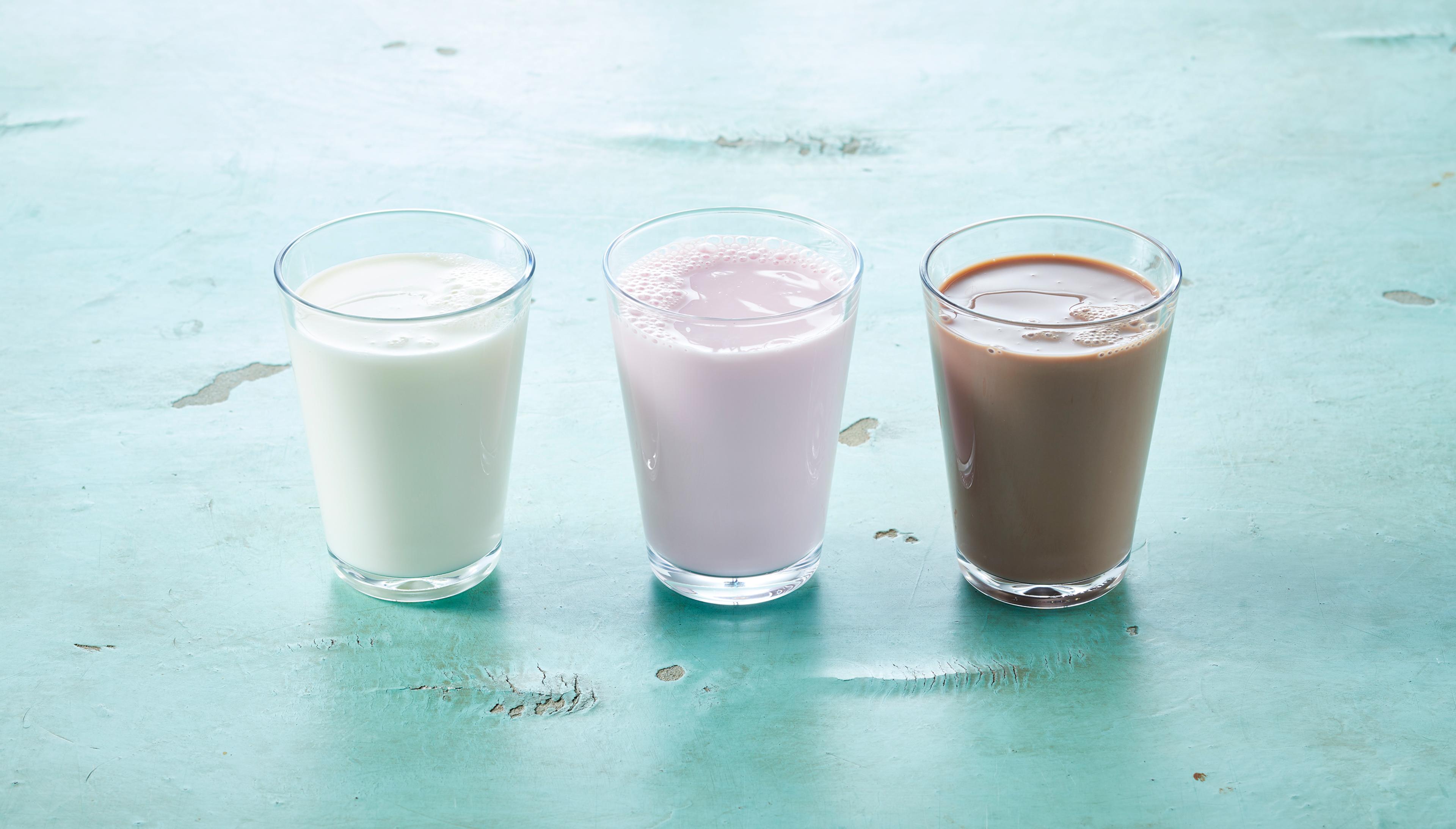 Tre glass melk med smak av jordbær, vanilje og sjokolade