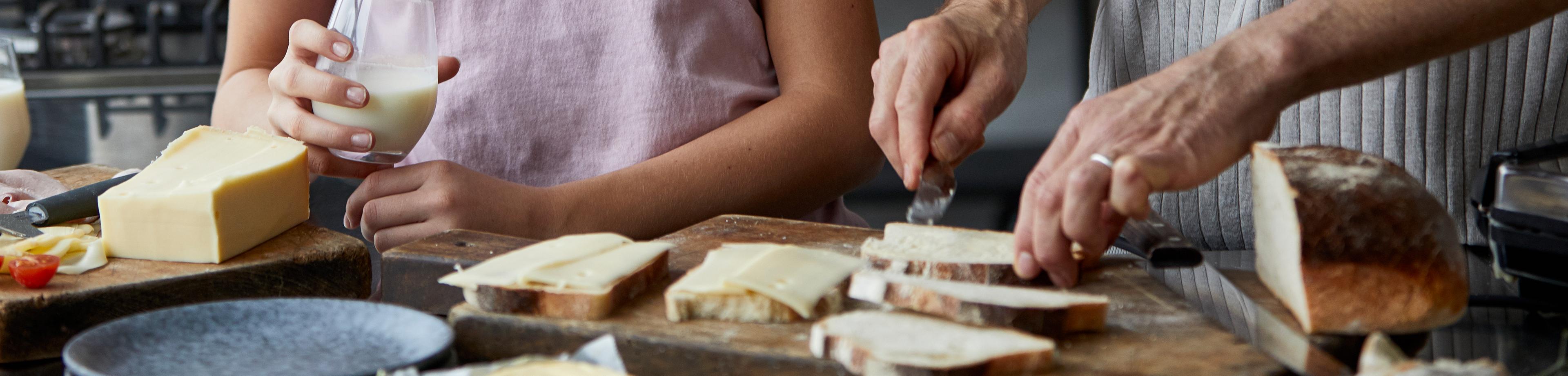 Jente lager toast med ost sammen med faren sin