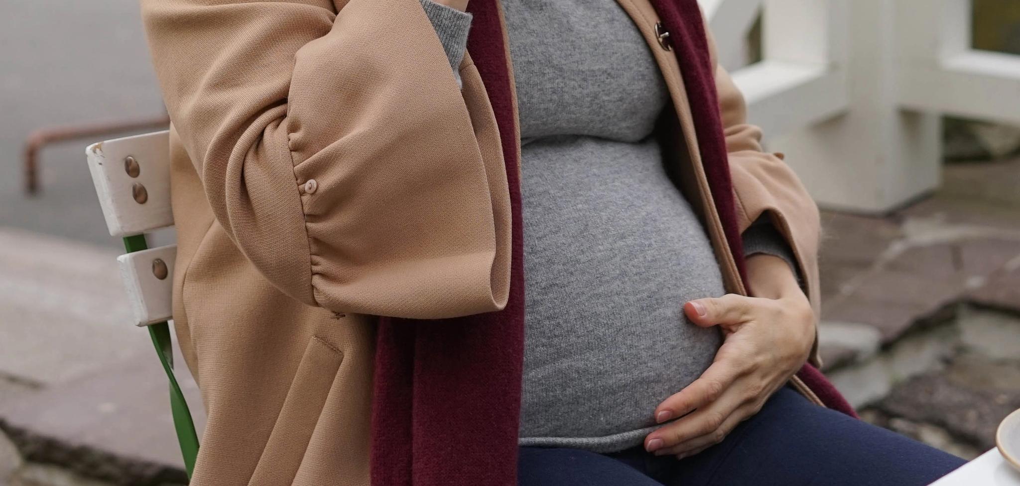 Gravid kvinner drikker kakao på ute-kafé