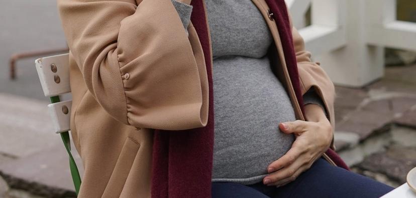 Gravid kvinner drikker kakao på ute-kafé