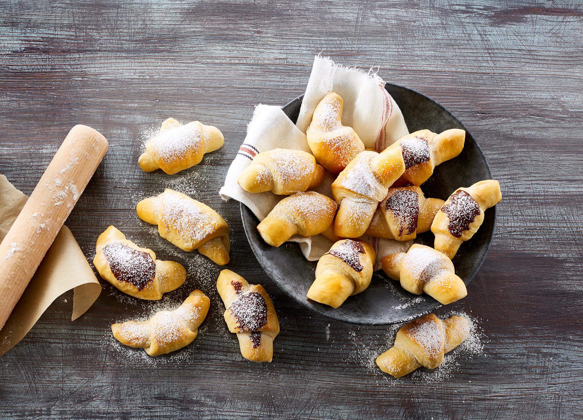 Kefirhorn med marsipan på et fat ved siden av en kopp kaffe