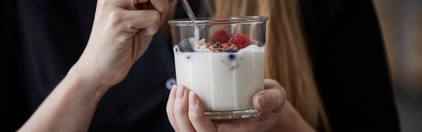 Kvinne spiser yoghurt med bær