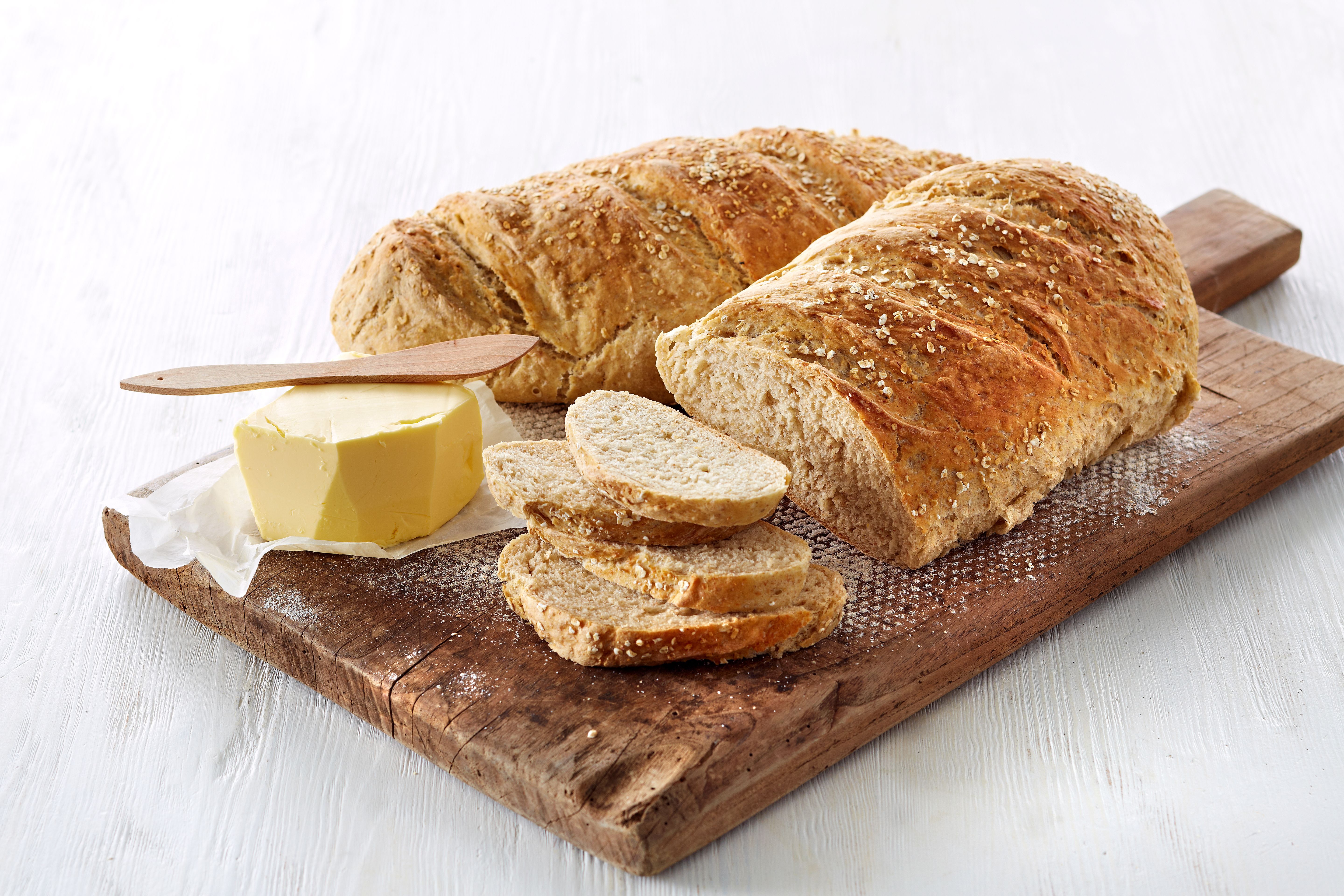 To grove havrebrød på en fjøl med en pakke smør