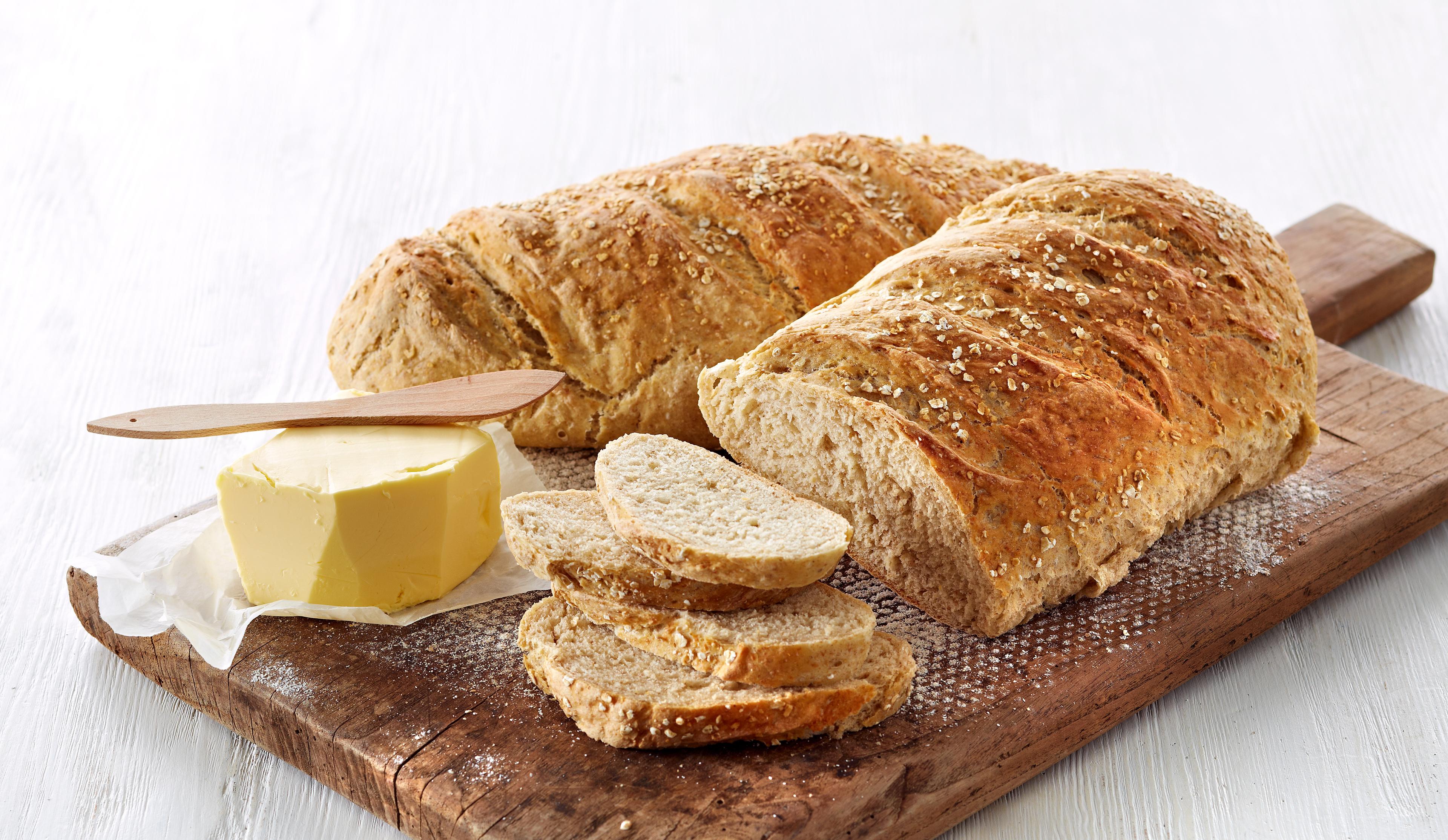 To grove havrebrød på en fjøl med en pakke smør