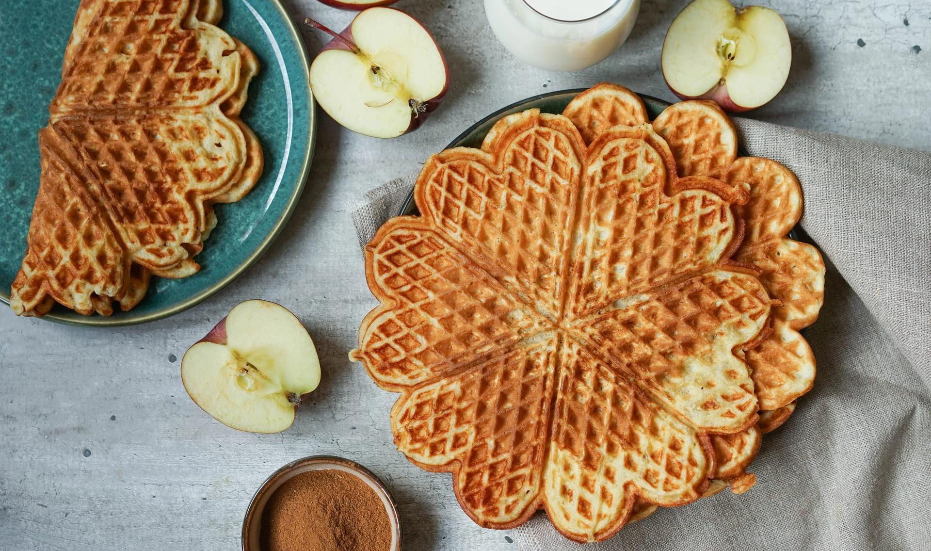 eplevafler med kanel i stabel med epler delt i to ved siden og et glass melk