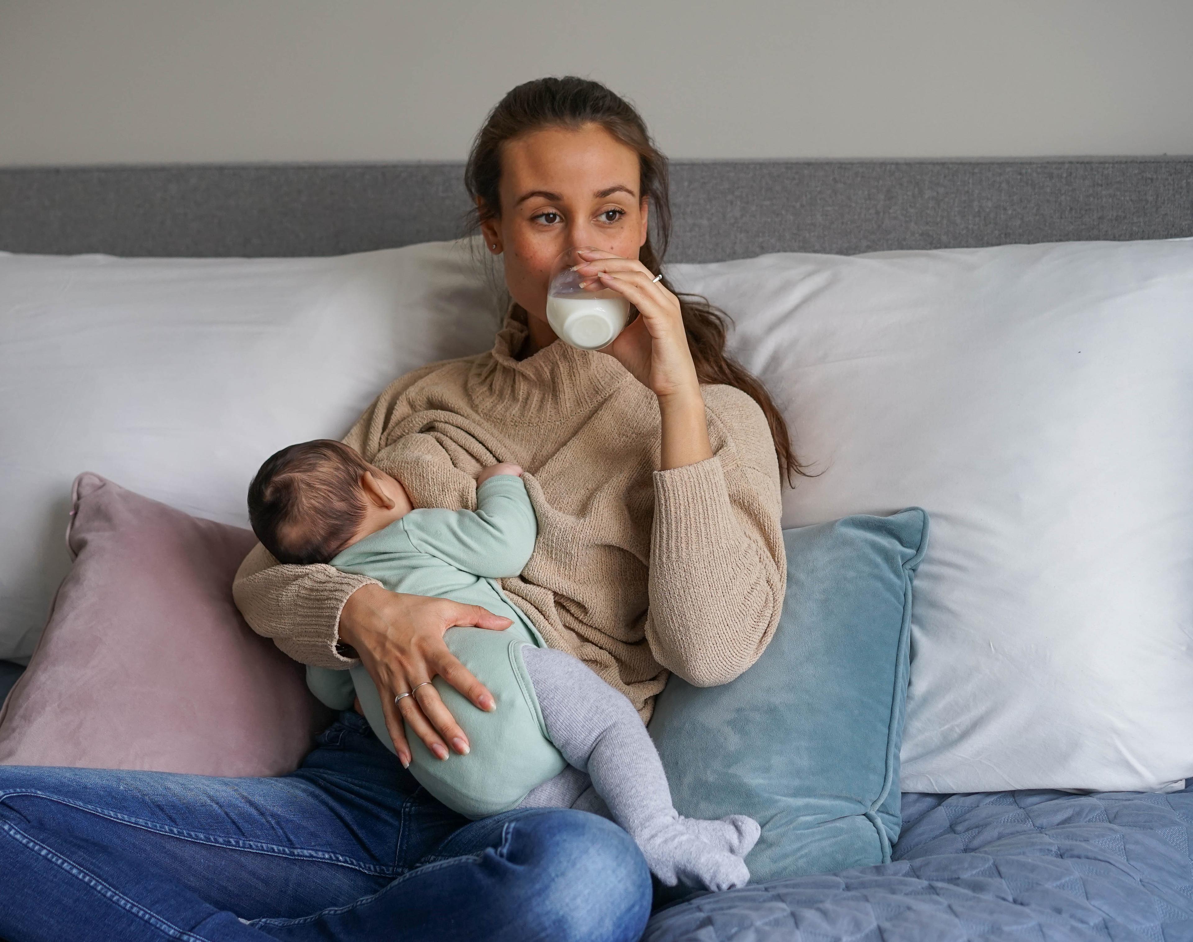 Mor som ammer baby og drikker melk