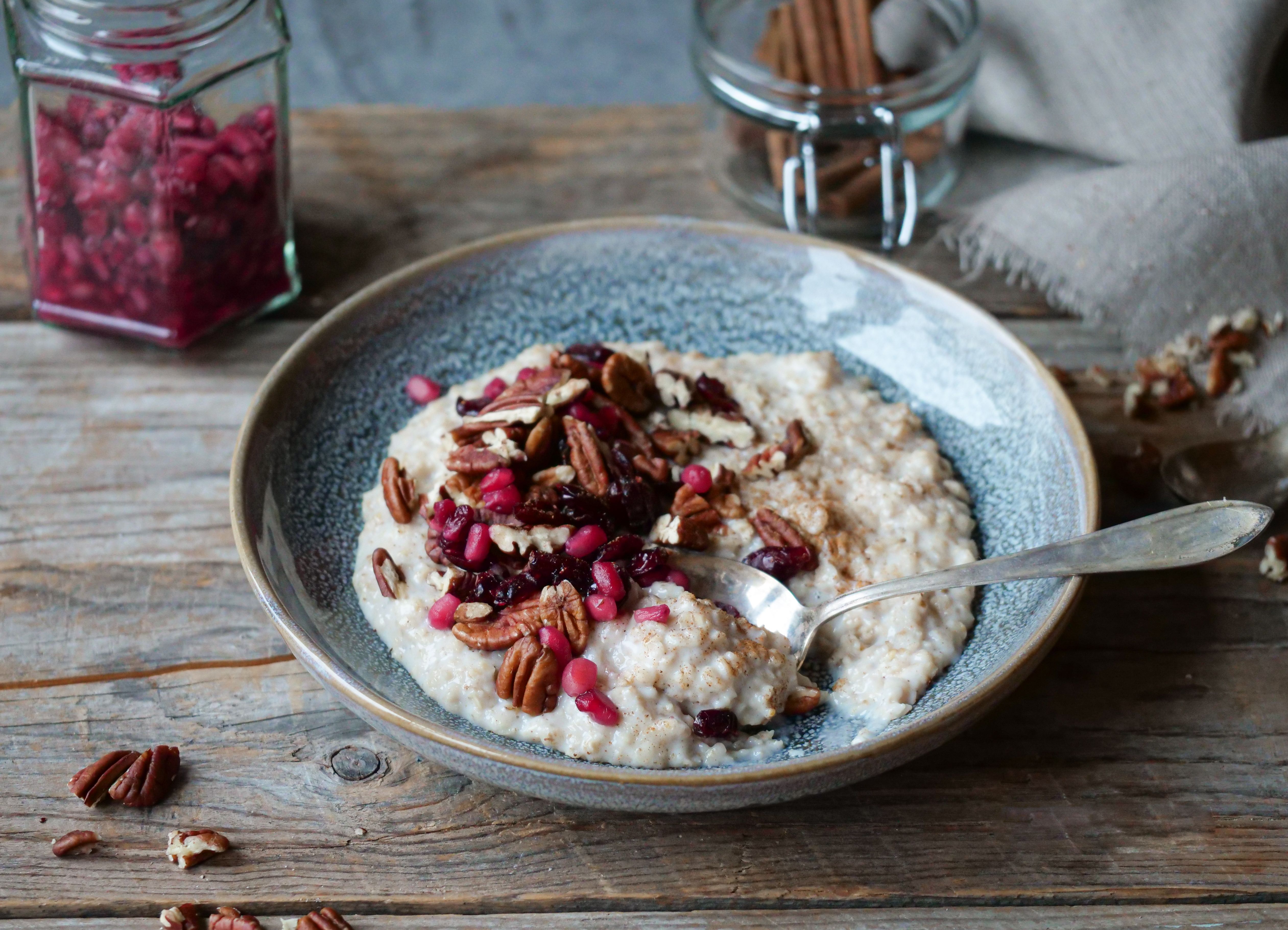 En bolle med havregrøt med pekannøtter, tranebær og granateplelkjerner 