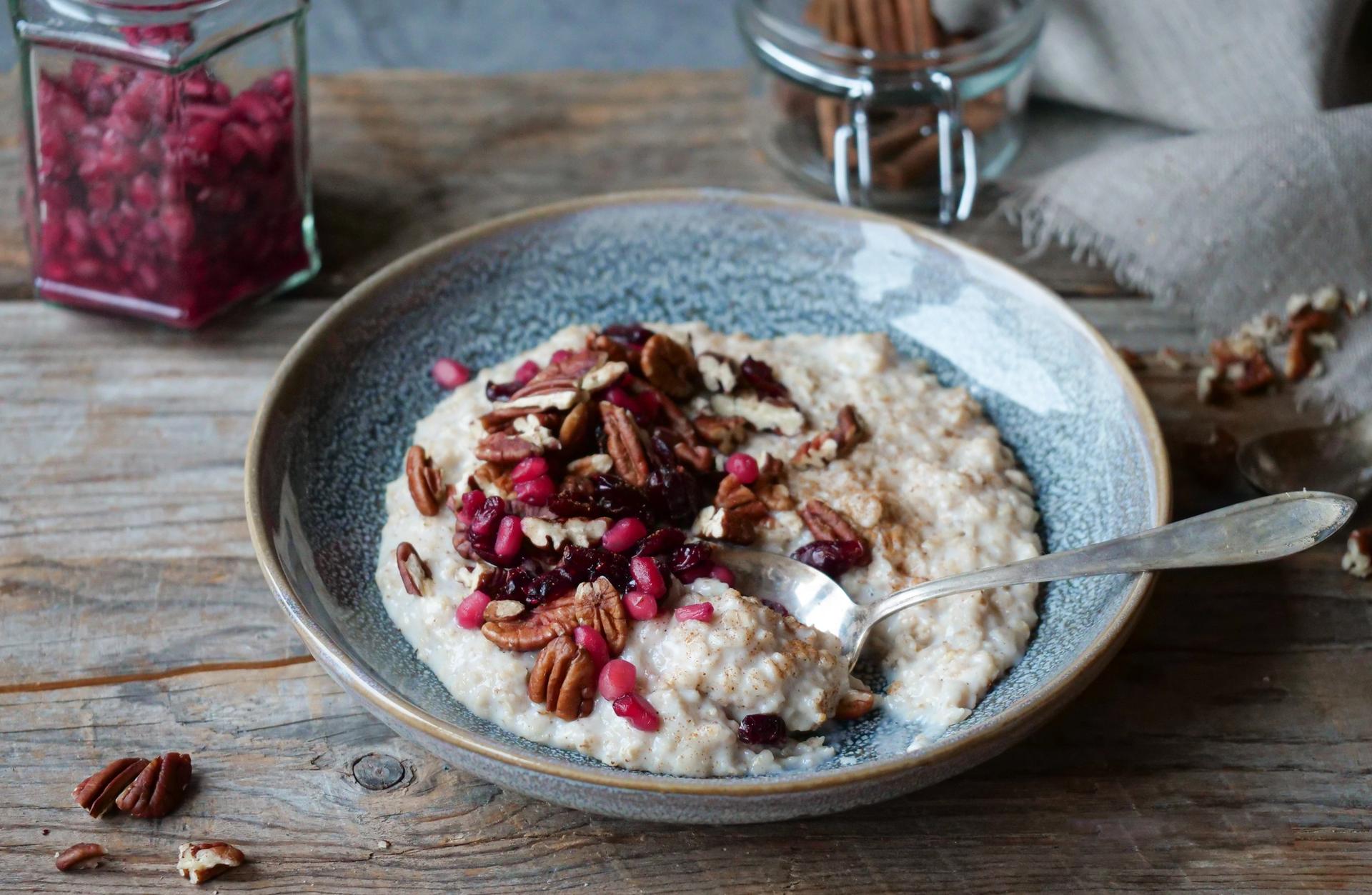 En bolle med havregrøt med pekannøtter, tranebær og granateplelkjerner