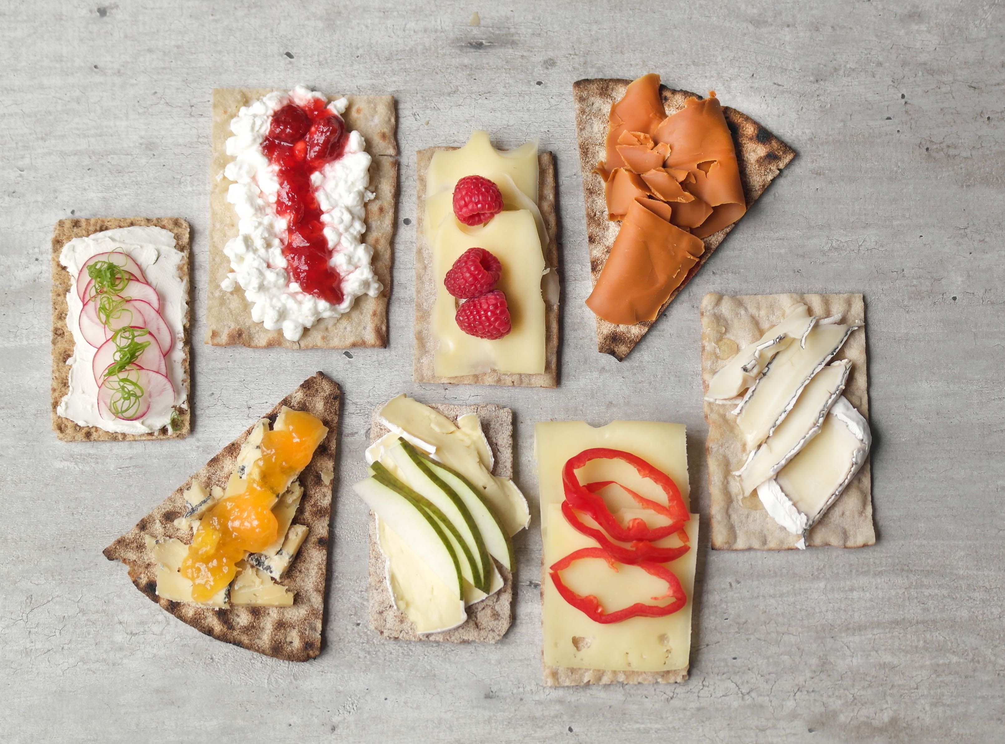 Flere knekkebrød med ulike oster og topping