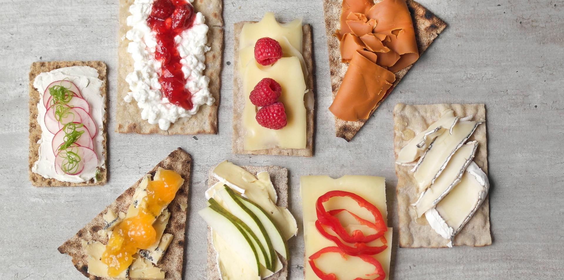 Flere knekkebrød med ulike oster og topping