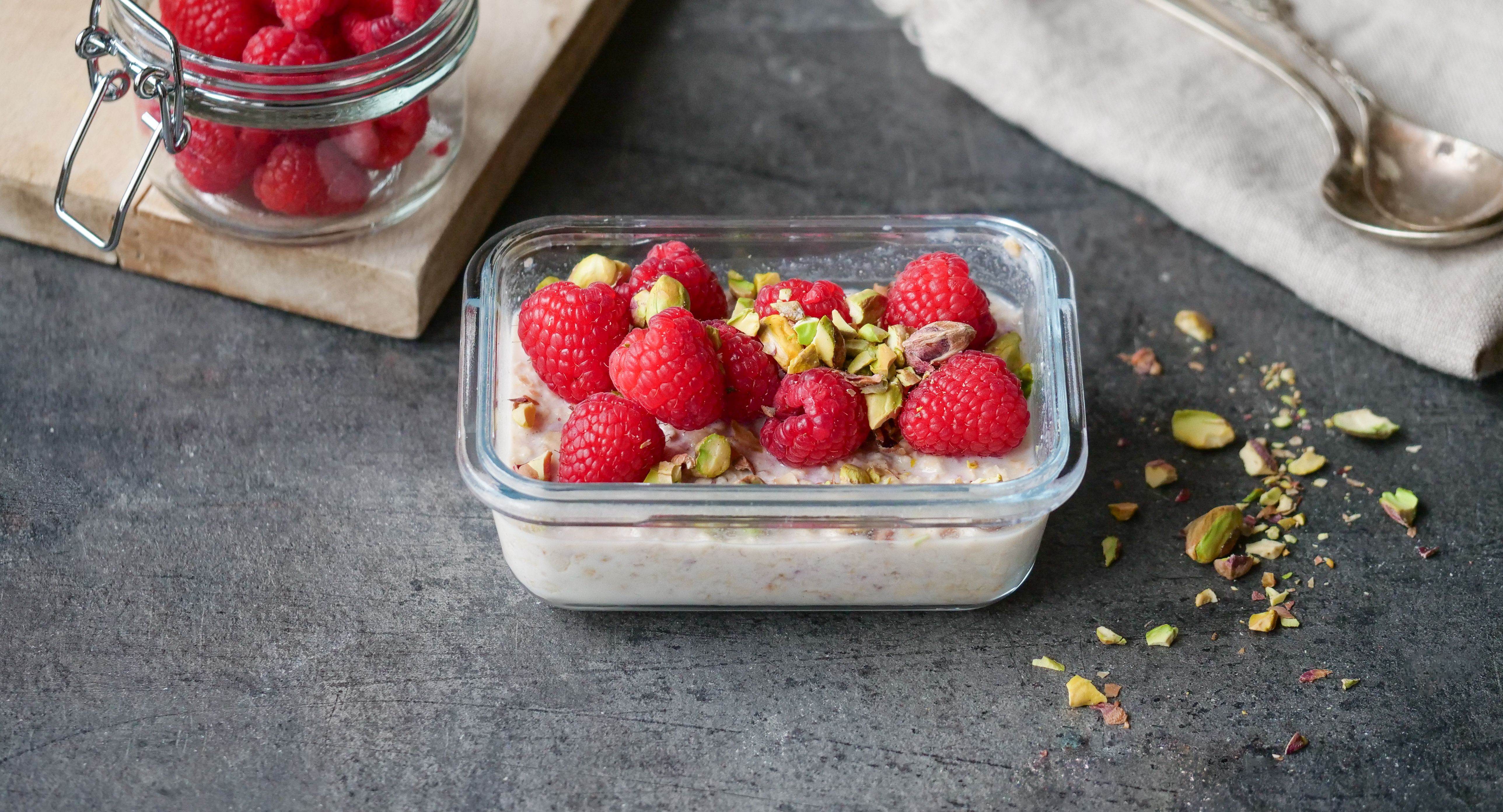 Kjøleskapsgrøt toppet med bringebær og hakkede pistasjnøtter 