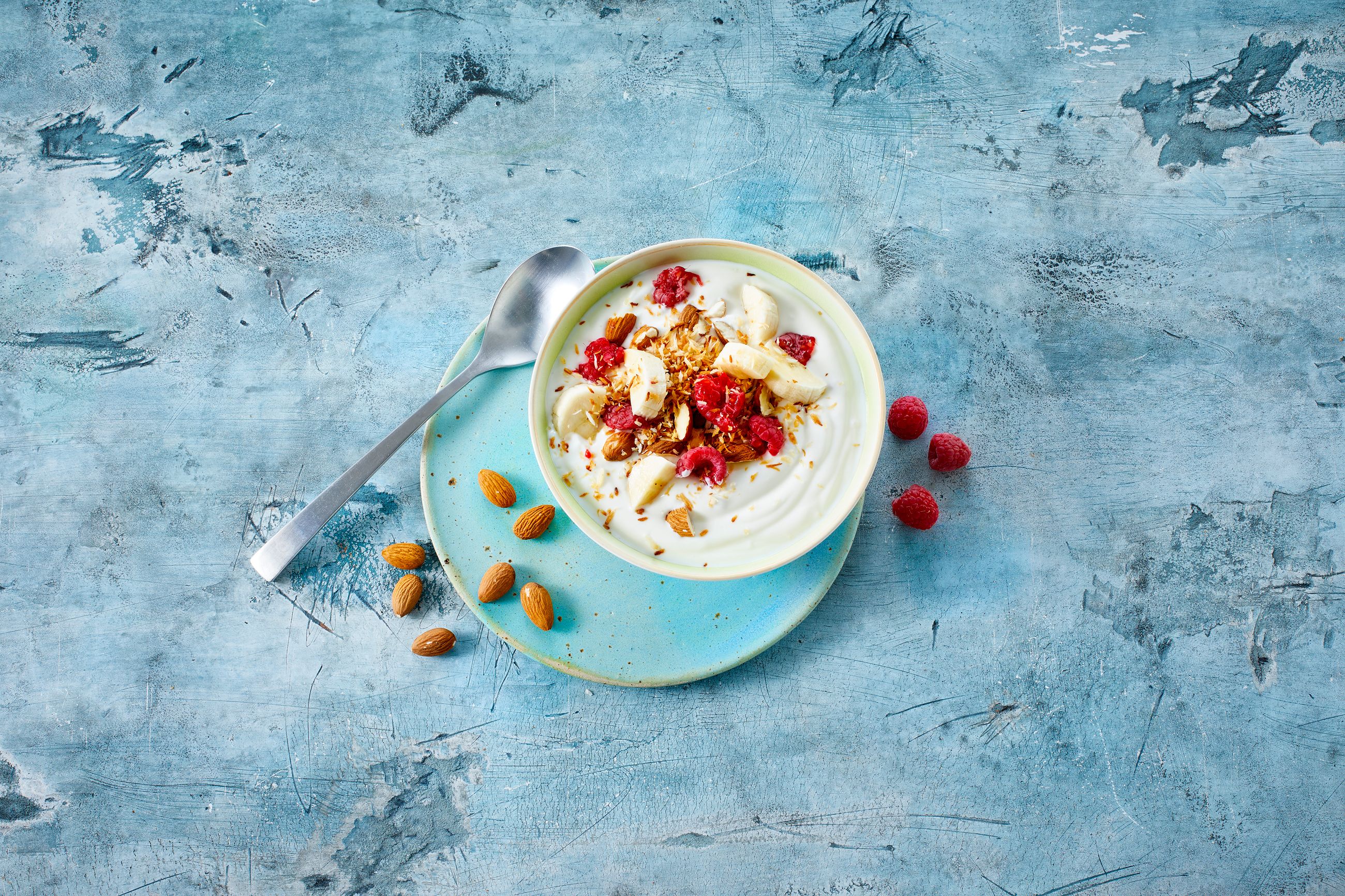 skål med yoghurt naturell, toppet med bringebær og hakkede mandler 