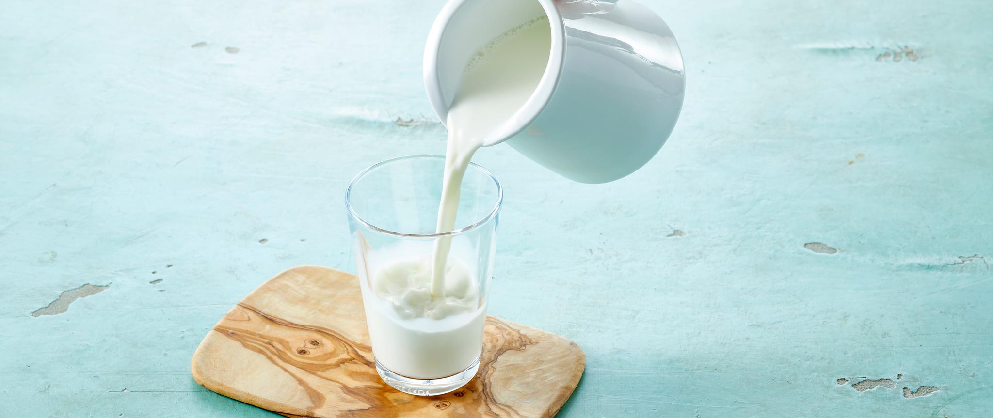 Melk som helles fra mugge til glass