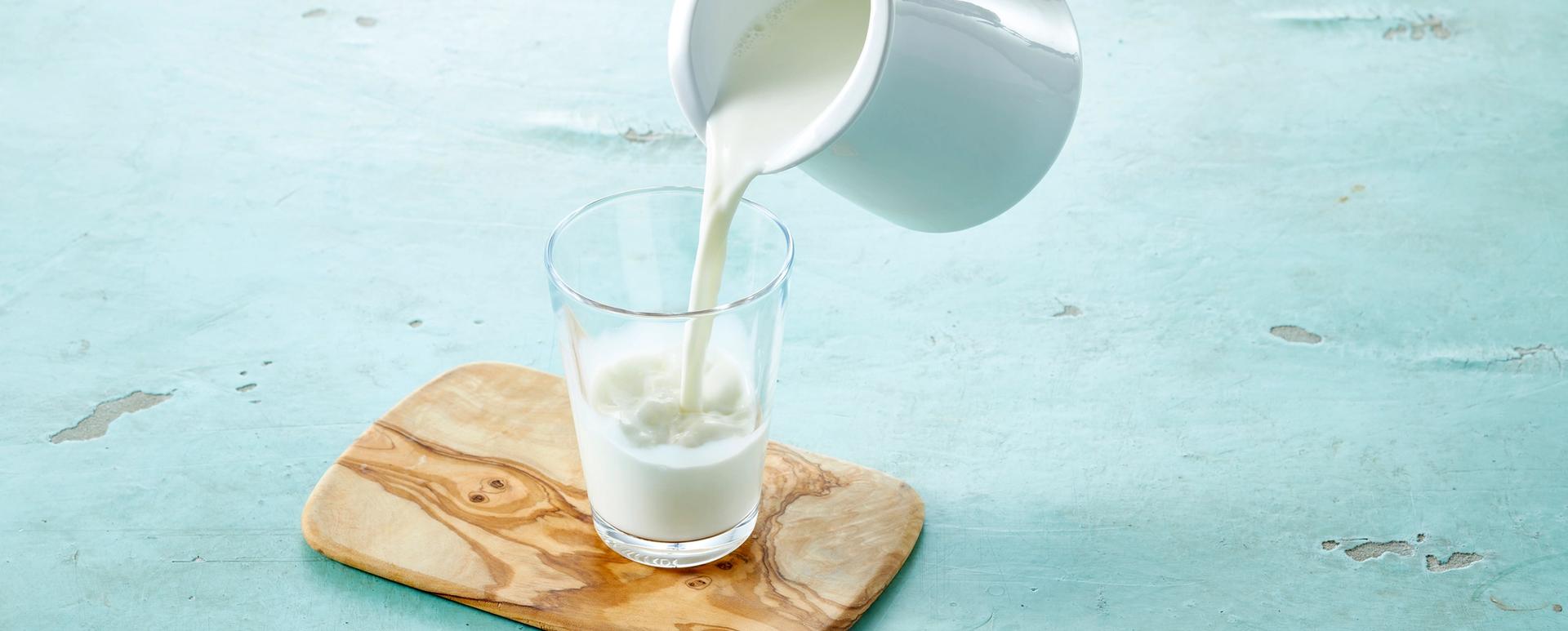 Melk som helles fra mugge til glass