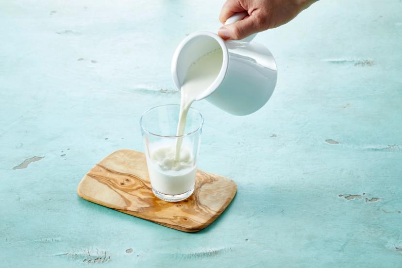 Melk som helles fra mugge til glass