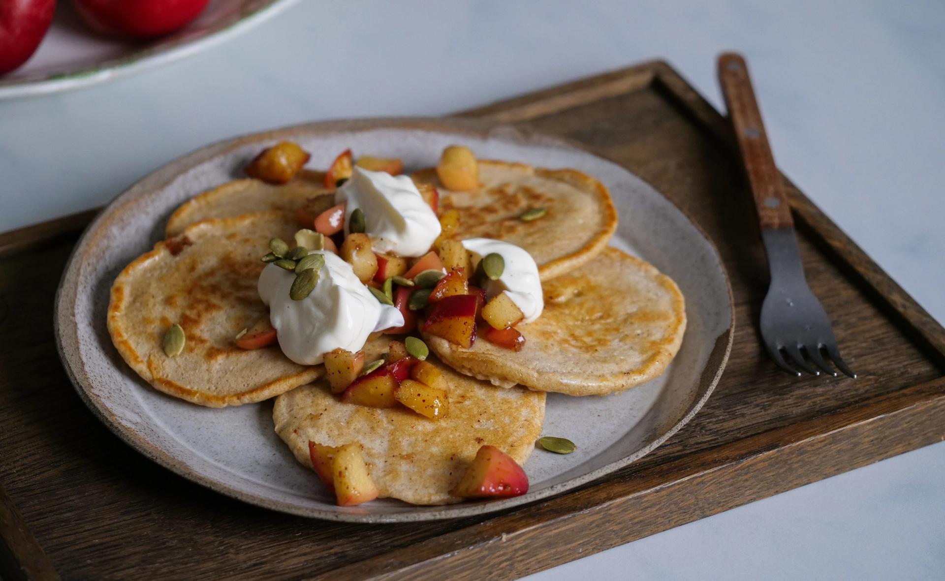 En tallerken med små pannekaker toppet med kvarg og lune epler