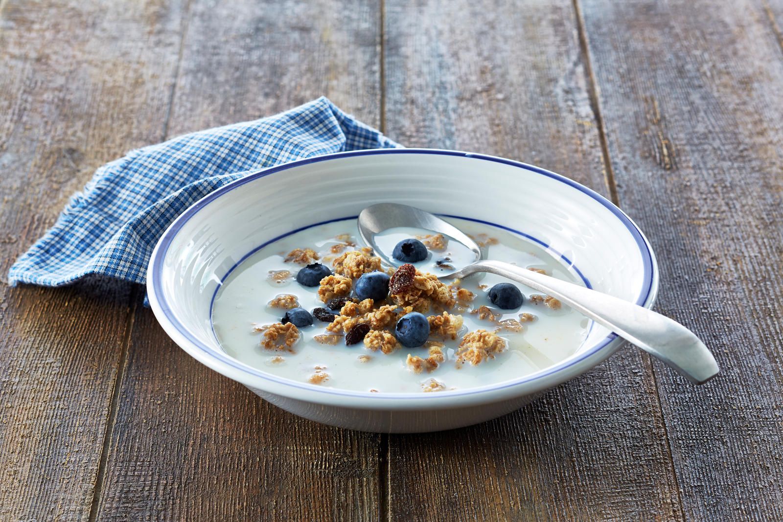 En skål med melk og kornblanding med blåbær.