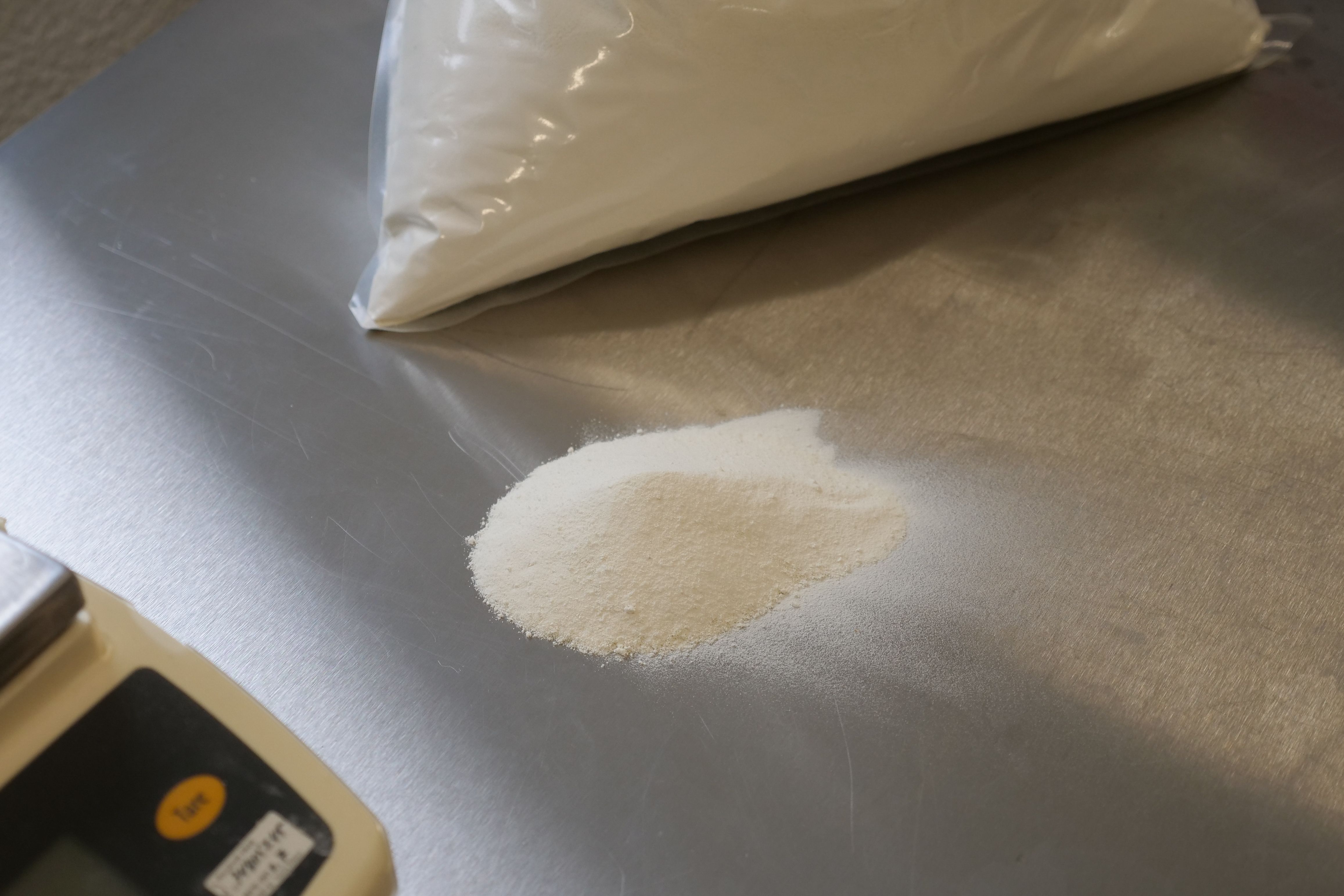 Melkepulver på metallbenk ved siden av vekt