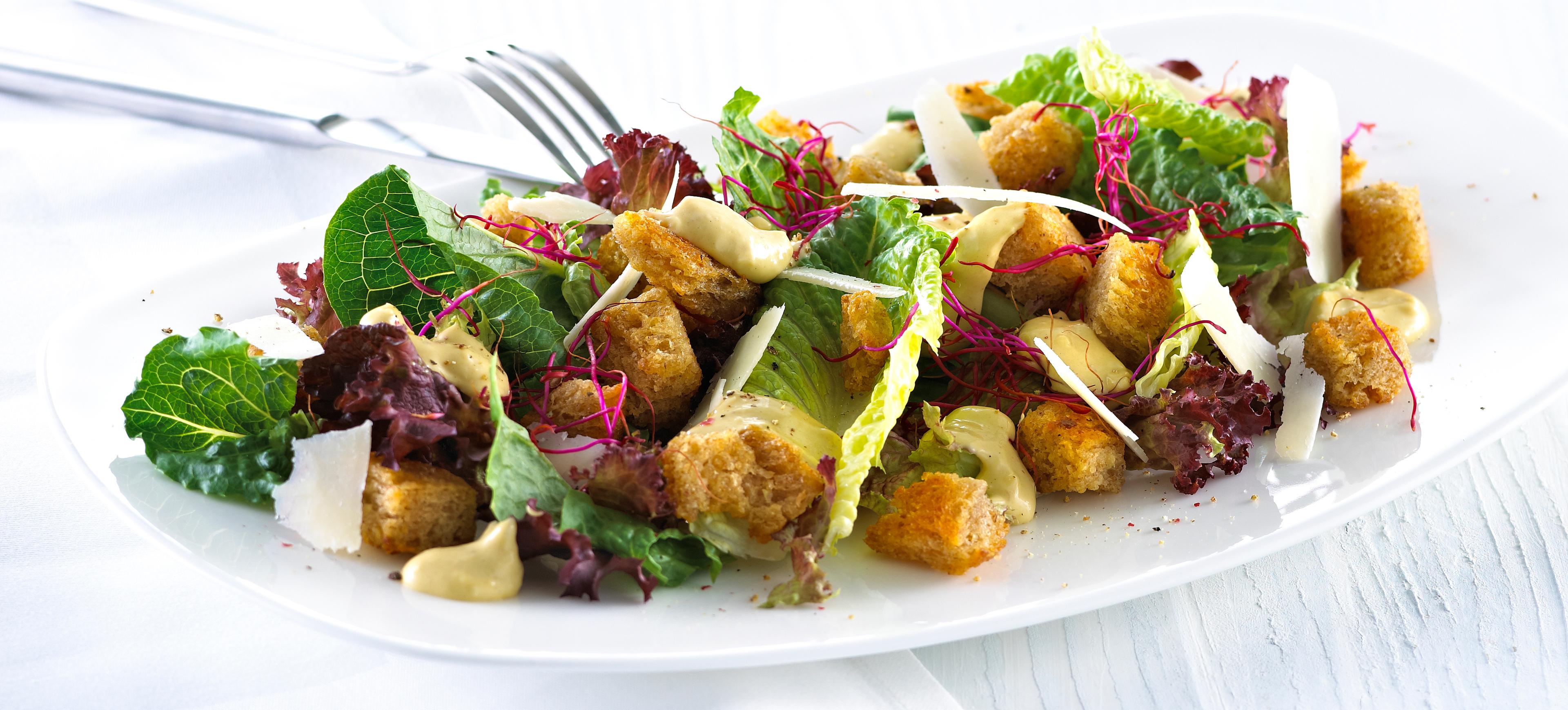 Blandet salat med krutonger og skivet parmesan.
