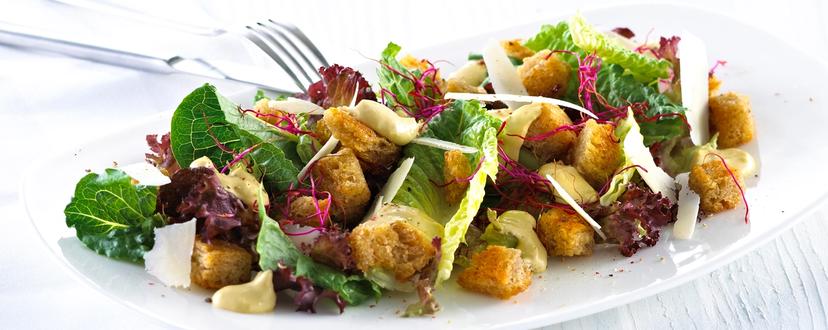 Blandet salat med krutonger og skivet parmesan.