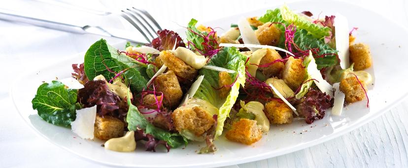 Blandet salat med krutonger og skivet parmesan.