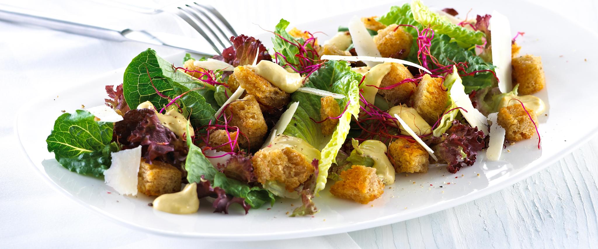 Blandet salat med krutonger og skivet parmesan.