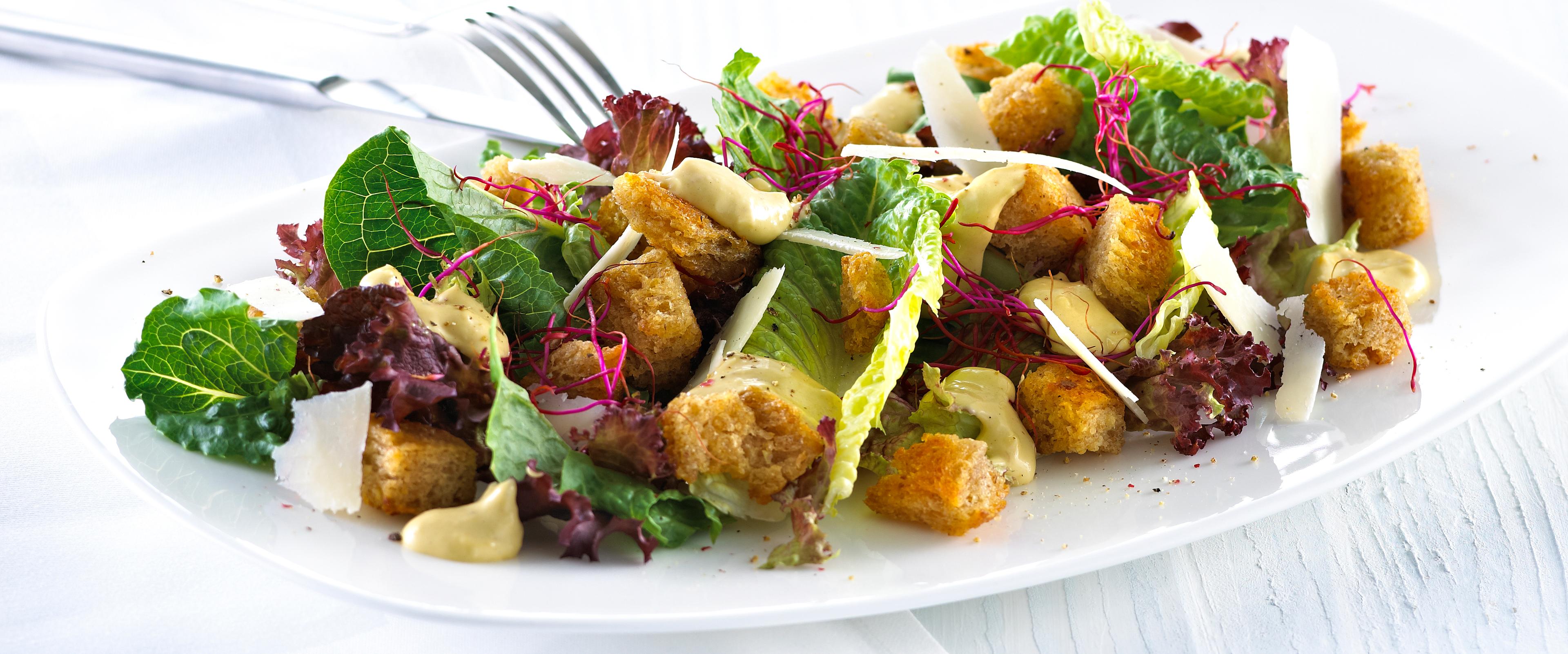 Blandet salat med krutonger og skivet parmesan.
