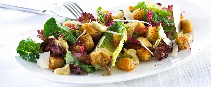 Blandet salat med krutonger og skivet parmesan.