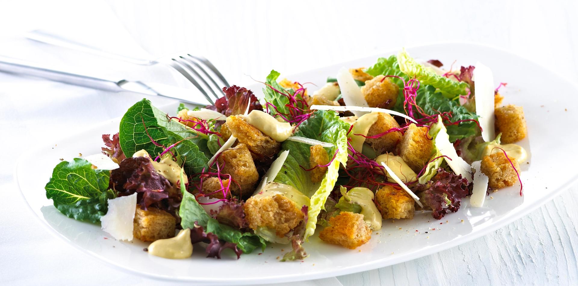 Blandet salat med krutonger og skivet parmesan.