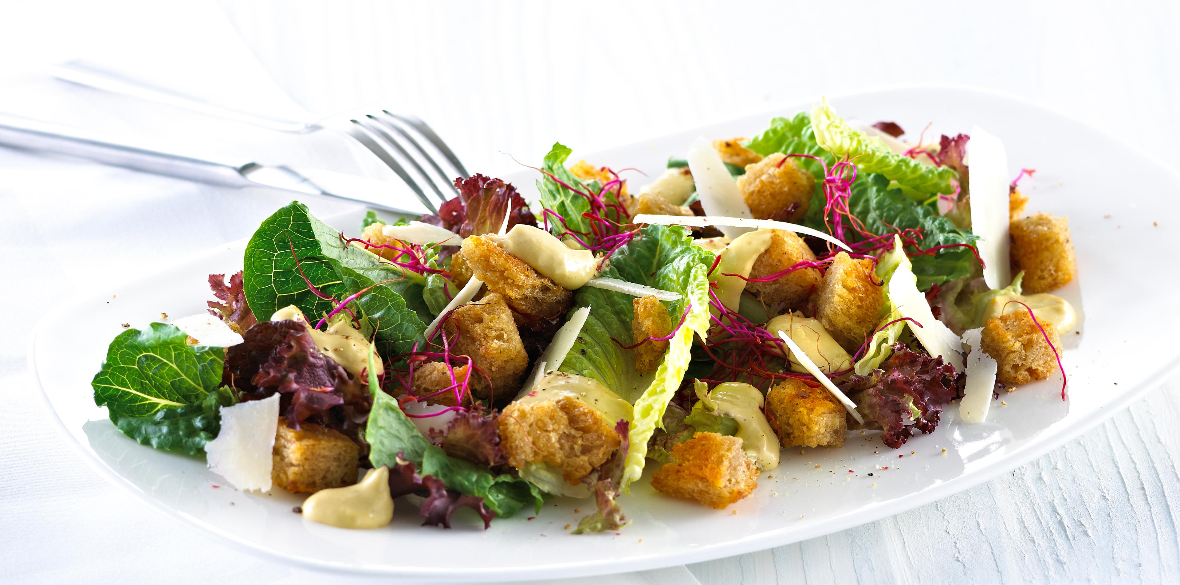 Blandet salat med krutonger og skivet parmesan.