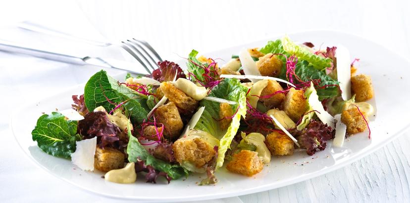 Blandet salat med krutonger og skivet parmesan.