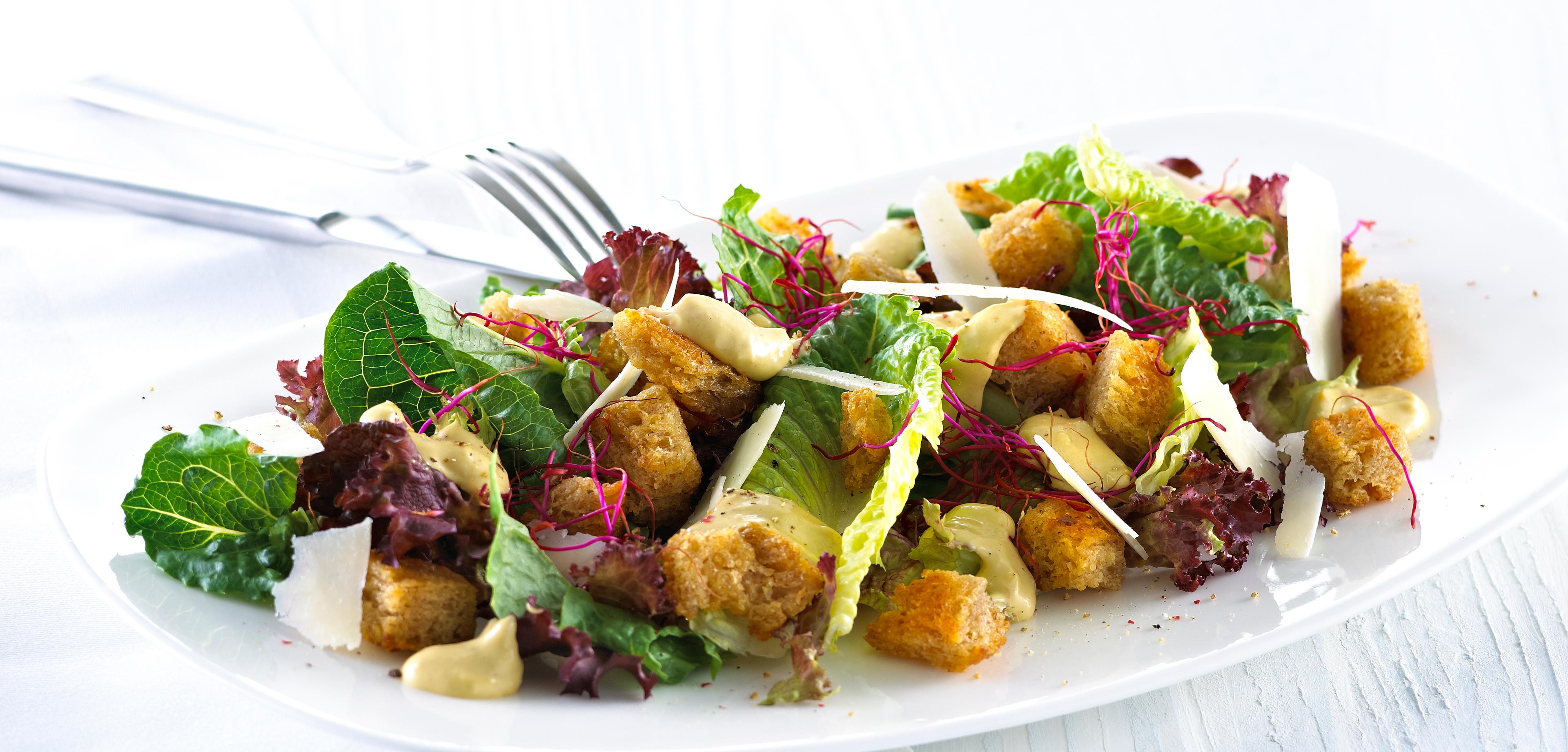 Blandet salat med krutonger og skivet parmesan.