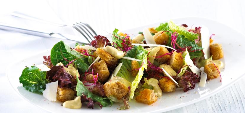 Blandet salat med krutonger og skivet parmesan.